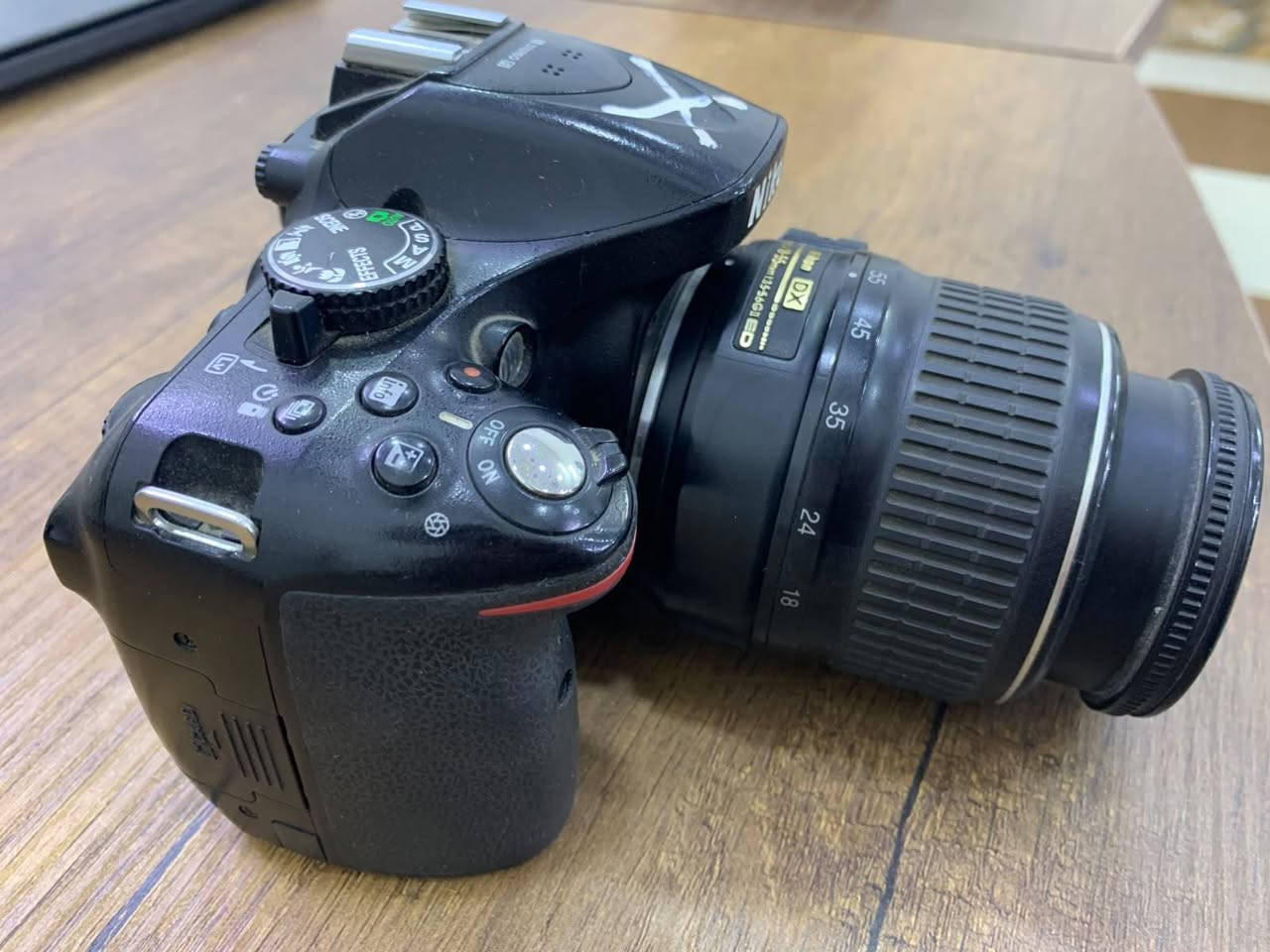 كاميرا Nikon D5200 هي واحدة من أشهر كاميرات DSLR للفئة المبتدئة والمقارب للمتوسطة التي قدمتها نيكون. على الرغم من إصدارها قبل عدة سنوات، إلا أنها لا تزال تقدم أداءً ممتازاً جداً بفضل مستشعرها القوي ومعالج الصور الخاص بها.
إليك المواصفات الكاملة والتفصيلية لكاميرا Nikon D5200:
📷 المواصفات الأساسية (Core Specs)
 * نوع الكاميرا: DSLR (بمرآة).
 * المستشعر (Sensor): من نوع CMOS بحجم APS-C (DX format).
 * دقة المستشعر: 24.1 ميجابكسل (تمنحك صوراً عالية الدقة وقابلة للاقتصاص والتكبير بوضوح ممتاز).
 * معالج الصور: EXPEED 3 (يساعد على معالجة الألوان بسرعة وتقليل الضوضاء "الـ Noise").
⚡ الأداء والسرعة
 * سرعة التصوير المتتابع (Continuous Shooting): تصل إلى 5 إطارات في الثانية (Fps)، وهي مناسبة لتصوير الحركة السريعة أو الأطفال والحيوانات الأليفة.
 * حساسية الضوء (ISO): تبدأ من 100 وتصل إلى 6400 (يمكن توسيعها رقمياً لتصل إلى 25600). أداؤها ممتاز في الإضاءة المنخفضة مقارنة بجيلها.
 * نظام التركيز التلقائي (Autofocus): يحتوي على 39 نقطة تركيز (منها 9 نقاط من النوع التصالبي Cross-type لزيادة الدقة)، وهو نظام تركيز قوي جداً ورثته من شقيقتها الأكبر D7000.
🎥 تصوير الفيديو (Video Capabilities)
 * دقة الفيديو: تصوير بجودة Full HD (1080p) بسرعة 60i أو 30p/24p إطار في الثانية.
 * الميكروفون: ميكروفون ستيريو مدمج (Stereo Mic) بفتحات أعلى الكاميرا لتسجيل صوت نقي، بالإضافة إلى منفذ ميكروفون خارجي (3.5mm) لمحترفي الصوت.
🖥️ الشاشة والتصميم
 * الشاشة: شاشة بمقاس 3.0 إنش قابلة للإمالة والتدوير بالكامل (Vari-angle)، وهي ممتازة جداً لالتقاط الصور من زوايا صعبة، أو لتصوير الفلوقات وصناعة المحتوى الشخصي.
 * دقة الشاشة: 921,000 نقطة (تمنحك وضوحاً ممتازاً لمعاينة الصور).
 * محدد الرؤية (Finder): محدد رؤية بصري (Pentamirror) يغطي حوالي 95% من الكادر.
🔋 البطارية والتوصيل
 * البطارية: من نوع EN-EL14، تكفي لالتقاط حوالي 500 صورة تقريباً بالشحنة الواحدة (حسب ظروف الاستخدام).
 * الاتصال: لا تحتوي على واي فاي مدمج (Wi-Fi)، ولكن يمكن توصيلها بقطعة خارجية (WU-1a) لنقل الصور لاسلكياً، وتدعم منافذ USB و HDMI.
> 💡 ملاحظة للمشتري:
> كاميرا Nikon D5200 لا تحتوي على محرك تركيز داخلي (Focus Motor) في جسم الكاميرا. هذا يعني أنه لتشغيل التركيز التلقائي (Autofocus)، يجب عليك استخدام عدسات نيكون التي تحتوي على محرك مدمج (والتي تحمل الرمز AF-S أو AF-P)، أما العدسات القديمة الـ (AF) فستعمل عليها بالتركيز اليدوي فقط.
>
الاستفسار الاتصال على. رقم***********@

