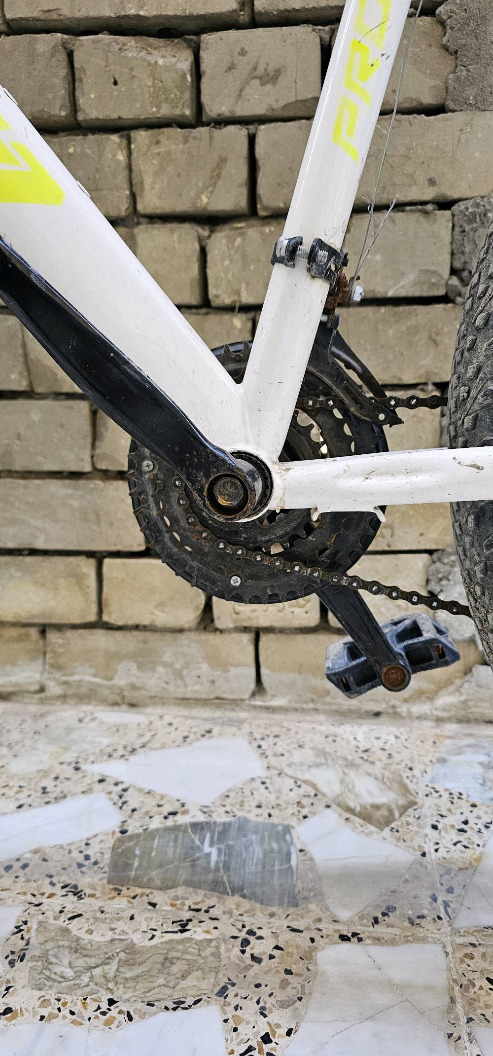 باسكل جبلي بحالة جيدة. اللون أبيض مع تفاصيل سوداء، يمتاز بإطارات عريضة للتضاريس الصعبة. مناسب لجولات الطرق الوعرة وقيادة مريحة في المناطق الجبلية.