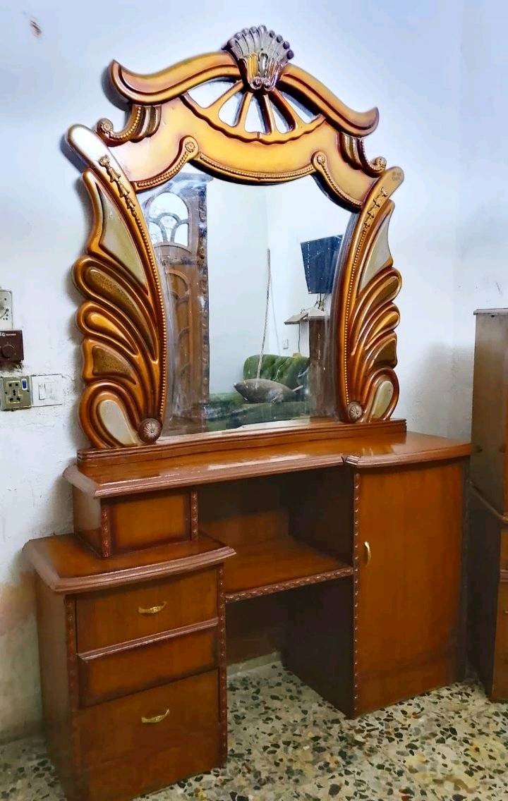 غرفة نوم مميزة بتصميم كلاسيكي أنيق، تتكون من سرير خشبي جميل، وخزانة كبيرة للتخزين بتصميم مزخرف، بالإضافة إلى مكتب تلبيس مع مرايا ودروج لتسهيل التنظيم. الأثاث مصنوع من الخشب عالي الجودة، مثالي لإضفاء لمسة من الفخامة والتنظيم على غرفة النوم.