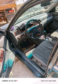 أنا أعرض سيارة كيا قديمة للبيع بلون أخضر غامق. السيارة ذات هيكل خارجي ...