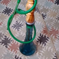 نركيلة خشبية ذات قاعدة زجاجية بلون أزرق وتظهر في حالة عامة جيدة. مزودة...