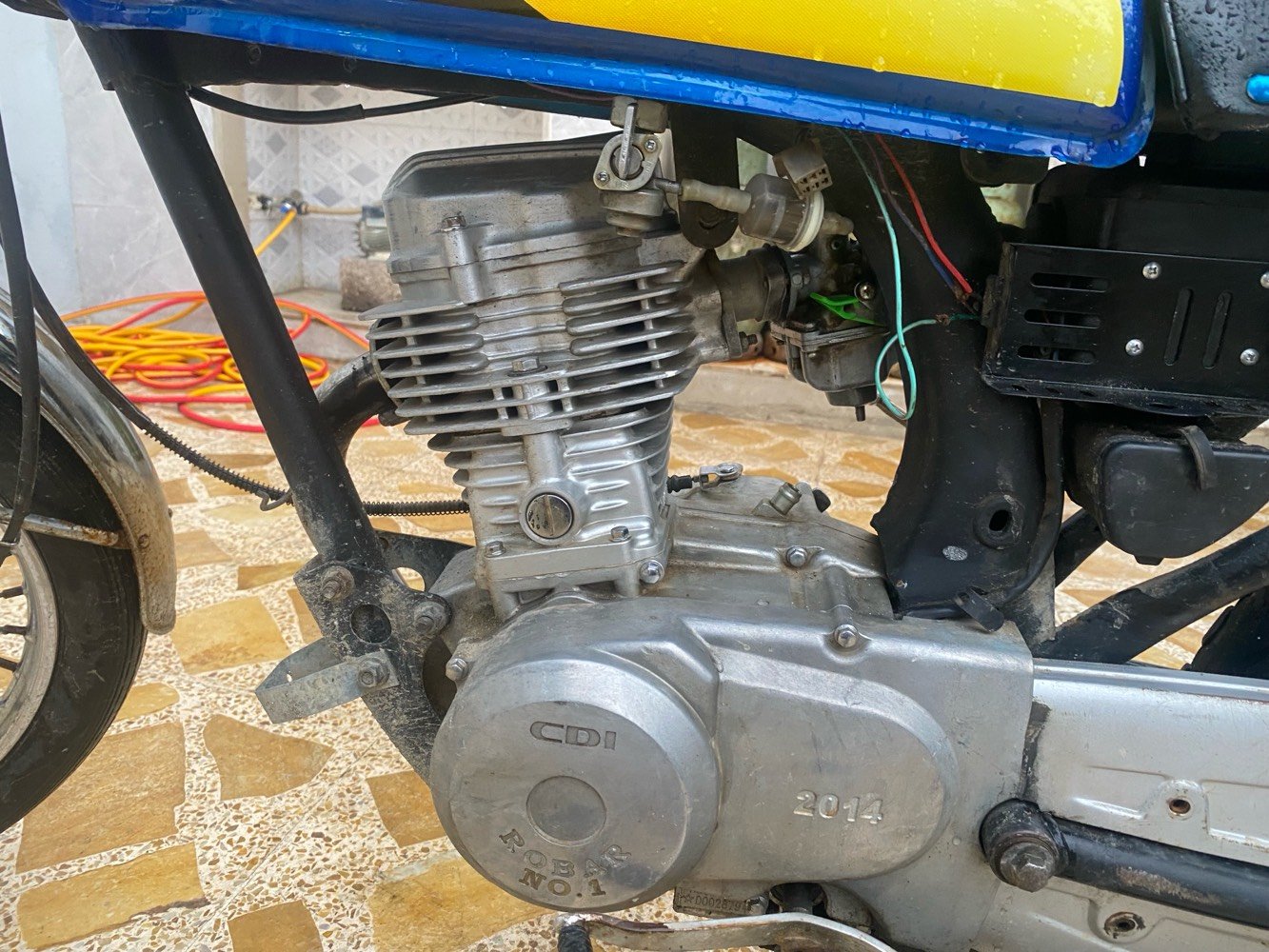 دراجة نارية بحالة جيدة مع محرك CDI ومحرك مُرقم 2014. اللون الأساسي أزرق مع تصميمات صفراء وسوداء على الجسم. مثالية للتنقل اليومي أو الرحلات القصيرة. تعمل بكفاءة وقوية في الأداء.