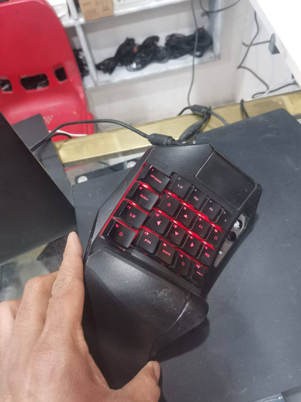 T.A.C.)، وهو عبارة عن لوحة مفاتيح مخصصة للألعاب (Keypad) مصممة خصيصاً لأجهزة البلايستيشن (PS4/PS3) والكمبيوتر.
إليك أهم مميزاته وما يظهره التصميم:
​الهدف الأساسي: يهدف الجهاز إلى منح لاعبي الكونسول تجربة تحكم تشبه "الماوس والكيبورد" في ألعاب التصويب (FPS) مثل Call of Duty أو Overwatch، مما يوفر دقة أعلى في الحركة والتصويب.
​تصميم الأزرار: تلاحظ أن الأزرار تحمل شعارات البلايستيشن (المثلث، الدائرة، المربع، x) بالإضافة إلى أزرار الأكتاف (L1, L2, R1, R2).    السعر قيم وبالعافيه موجود توصيل  رقم ***********📲
