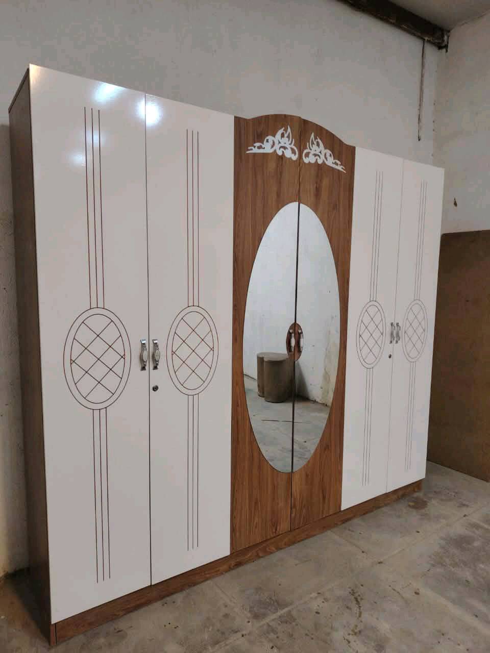 مجموعة غرفة نوم جديدة تحتوي على خزانات واسعة ومرآة وطاولة زينة مصنوعة من خشب متين. التصميم يجمع بين الأناقة والخطوط العصرية مع لمسات كلاسيكية. مثالية لإضفاء لمسة جمالية على غرفة النوم.