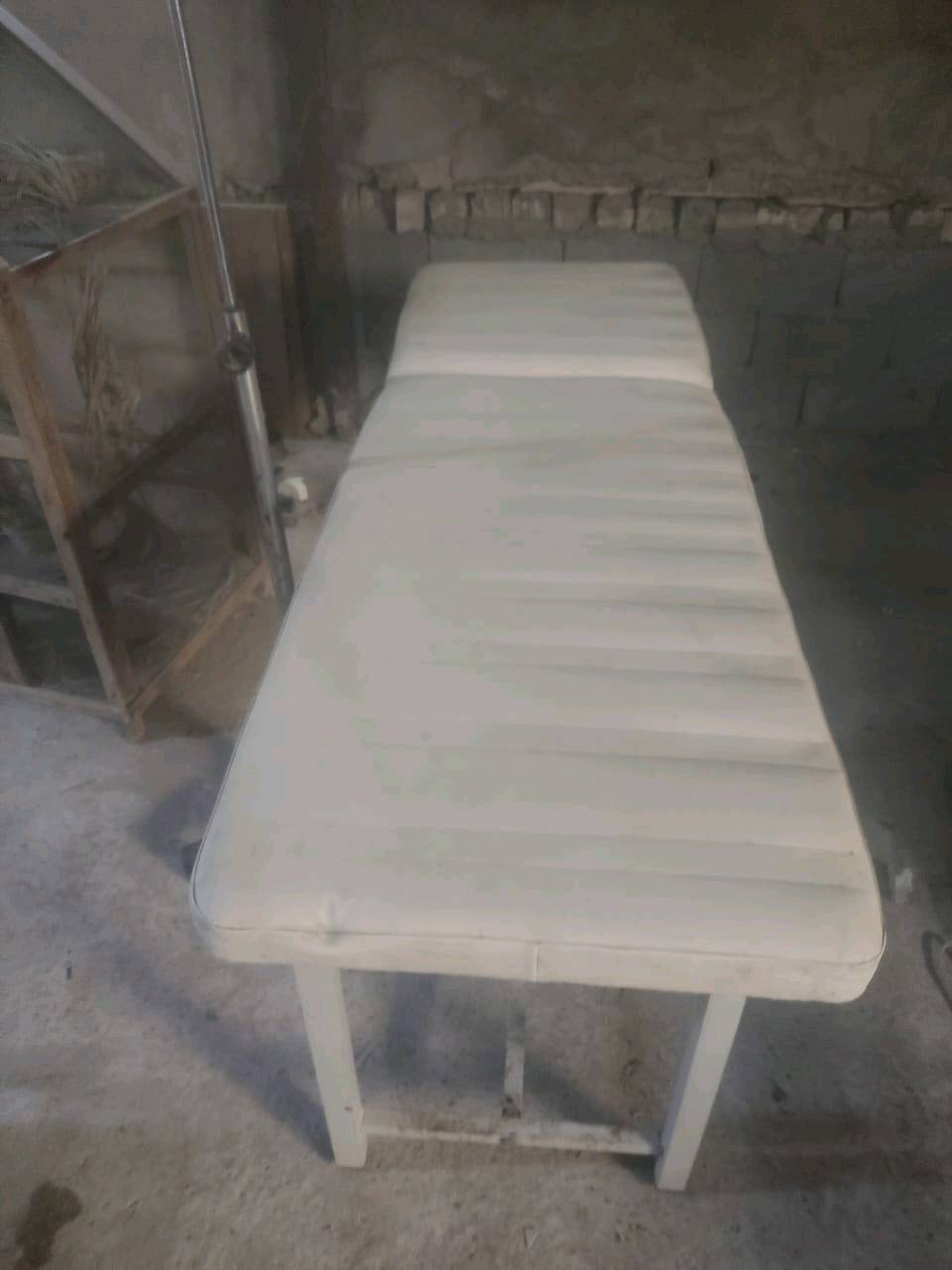 سرير طبي للاستخدام في العيادات أو المستشفيات، يتكون من هيكل معدني بلون أبيض مع مرتبة مريحة. مناسب للفحوصات الطبية والإجراءات البسيطة. القاعدة مجهزة بعجلات لسهولة النقل ويتضمن عمود لتعليق السوائل الطبية. صالح للاستخدام ويمكن تجديده عند الحاجة.