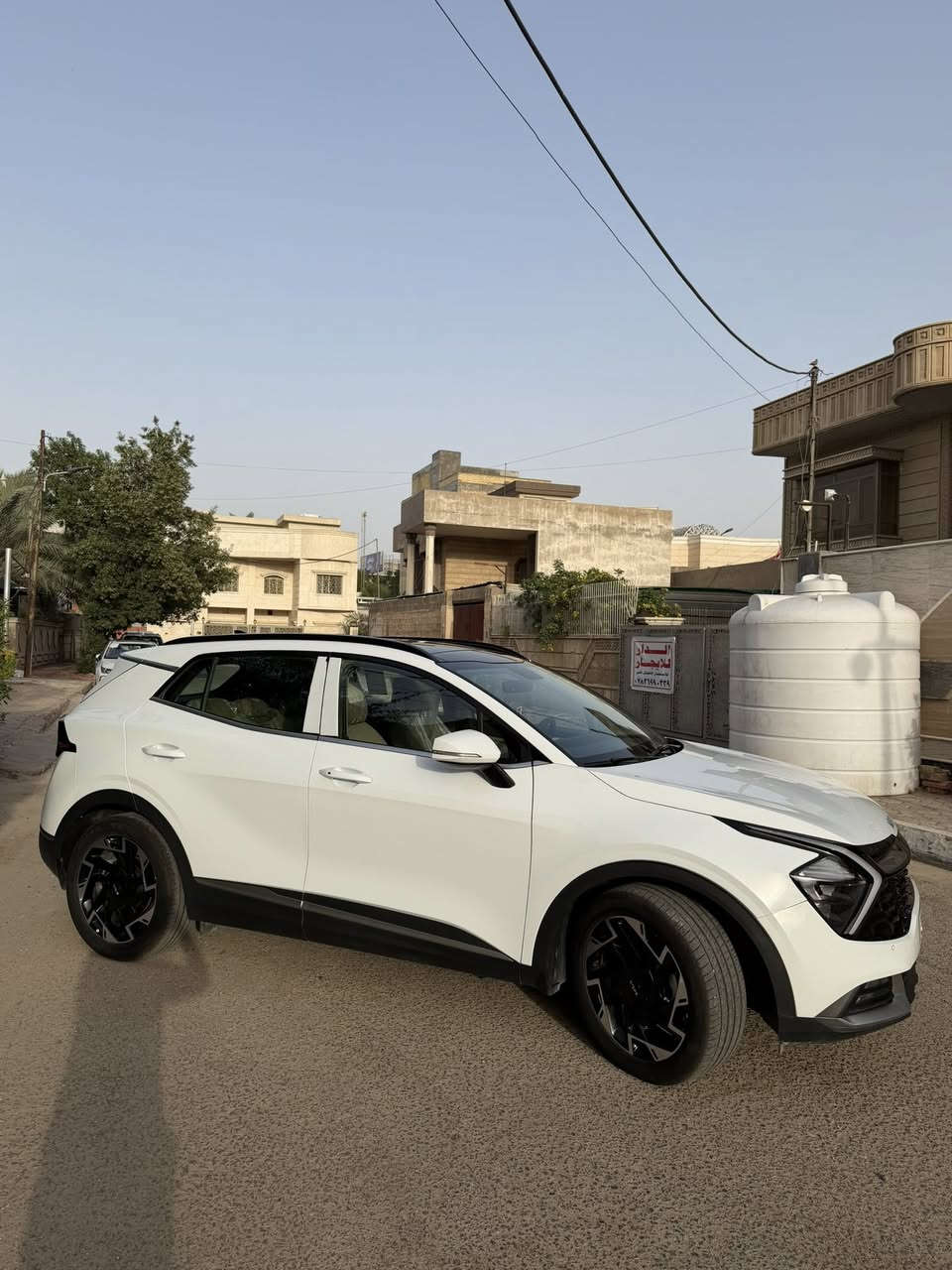 كيا سبورتج موديل 2025 للبيع خليجي العنوان البصرة الجزائر للأستفسار ومعرفة السعر يرجى التواصل على الرقم المذكور 

0780 722 1133

ممشى السياره 11195 قابل للزياده

السقف: سقف بانورامي كامل باللون الأسود يعطي السيارة مظهراً رياضياً (Two-Tone) مع فتحة سقف كهربائية كبيرة.
العجلات (الويلات): تأتي بفتحات تهوية وبتصميم رياضي مميز بلونين (كروم مع أسود) بمقاس19 إنش.
الحساسات والكاميرا: مستشعرات (حساسات) خلفية للمساعدة على الركن، بالإضافة إلى كاميرا خلفية تظهر بوضوح في شاشة الملاحة أثناء الرجوع.
المرايا الجانبية: كهربائية تحتوي على إشارات انعطاف LED.
2. المقصورة الداخلية والراحة
المقاعد: مقاعد بيج فاتح مميزة بتصميم مريح، تجمع بين القماش عالي الجودة والجلد على الأطراف.
شاشة العدادات: شاشة رقمية بالكامل (Digital Cluster) تعرض السرعة والـ RPM والمعلومات الأساسية بشكل عصري.
الشاشة الوسطية: شاشة لمس تدعم نظام الترفيه، الكاميرا الخلفية، وأنظمة الاتصال (مثل Apple CarPlay و Android Auto).
المقود (الستيرن): مقود جلدي رياضي يحتوي على تحكم كامل (ميديا، مثبت سرعة، بلوتوث) مع وجود شيفتات خلف المقود (Paddle Shifters) للتحكم اليدوي بنواقل الحركة (النمر).
3. الكونسول الوسطي وأنظمة القيادة
ناقل الحركة (الجير): عصا جير أوتوماتيكية بتصميم كلاسيكي أنيق.
أنظمة القيادة (Drive Modes): قرص دائري للتحكم تأتي بأربع وضعيات قياده (,Sportرياضي ،Smartذكي ،اقتصادي Eco، مريح Comfort، )
النظام الصوتي والترفيه: منافذ شحن USB و Type-C في الأمام وخلف المقاعد.
مكابح اليد: بريك إلكتروني (EPB) مع ميزة التوقف التلقائي (Auto Hold).
التحكم بالمنحدرات: زر نظام المساعدة على نزول المنحدرات (DBC).
4. المحرك والأداء (المواصفات الخليجية المعتادة)
عادةً ما تأتي هذه الفئة من السبورتج الخليجي بأحد الخيارين للمحرك (والأرجح للمواصفات الظاهرة):
المحرك: 4 سلندر، بسعة 2.0 نظام الدفع: دفع أمامي الفئة لتوخير استهلاك الوقود.
