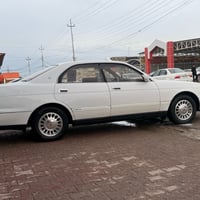 سيارة صالون بيضاء اللون بحالة جيدة، توفر راحة وقيادة مريحة. مناسبة للع...