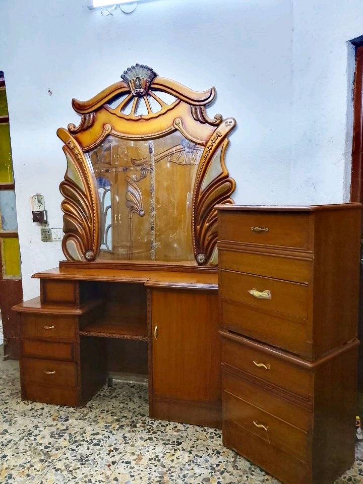 غرفة نوم مميزة بتصميم كلاسيكي أنيق، تتكون من سرير خشبي جميل، وخزانة كبيرة للتخزين بتصميم مزخرف، بالإضافة إلى مكتب تلبيس مع مرايا ودروج لتسهيل التنظيم. الأثاث مصنوع من الخشب عالي الجودة، مثالي لإضفاء لمسة من الفخامة والتنظيم على غرفة النوم.