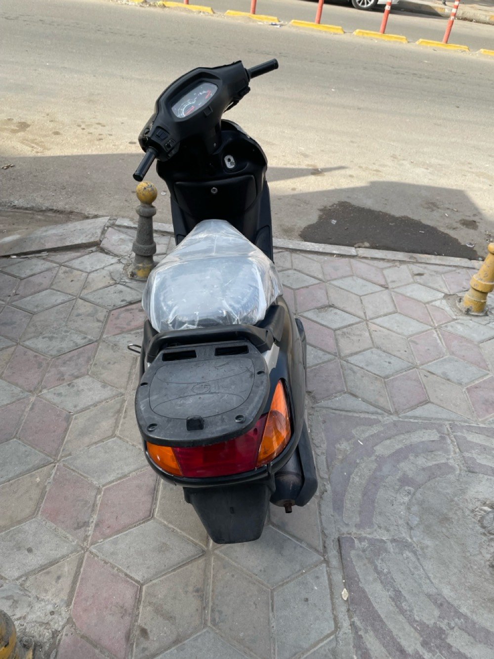 دراجة نارية نوع هوندا بحالة جيدة للبيع. اللون أسود والمقعد مغطى بكيس للحماية. الدراجة تناسب الاستخدام اليومي وتتمتع بقيادة مريحة وسلسة. مناسبة للتنقل داخل المدينة.