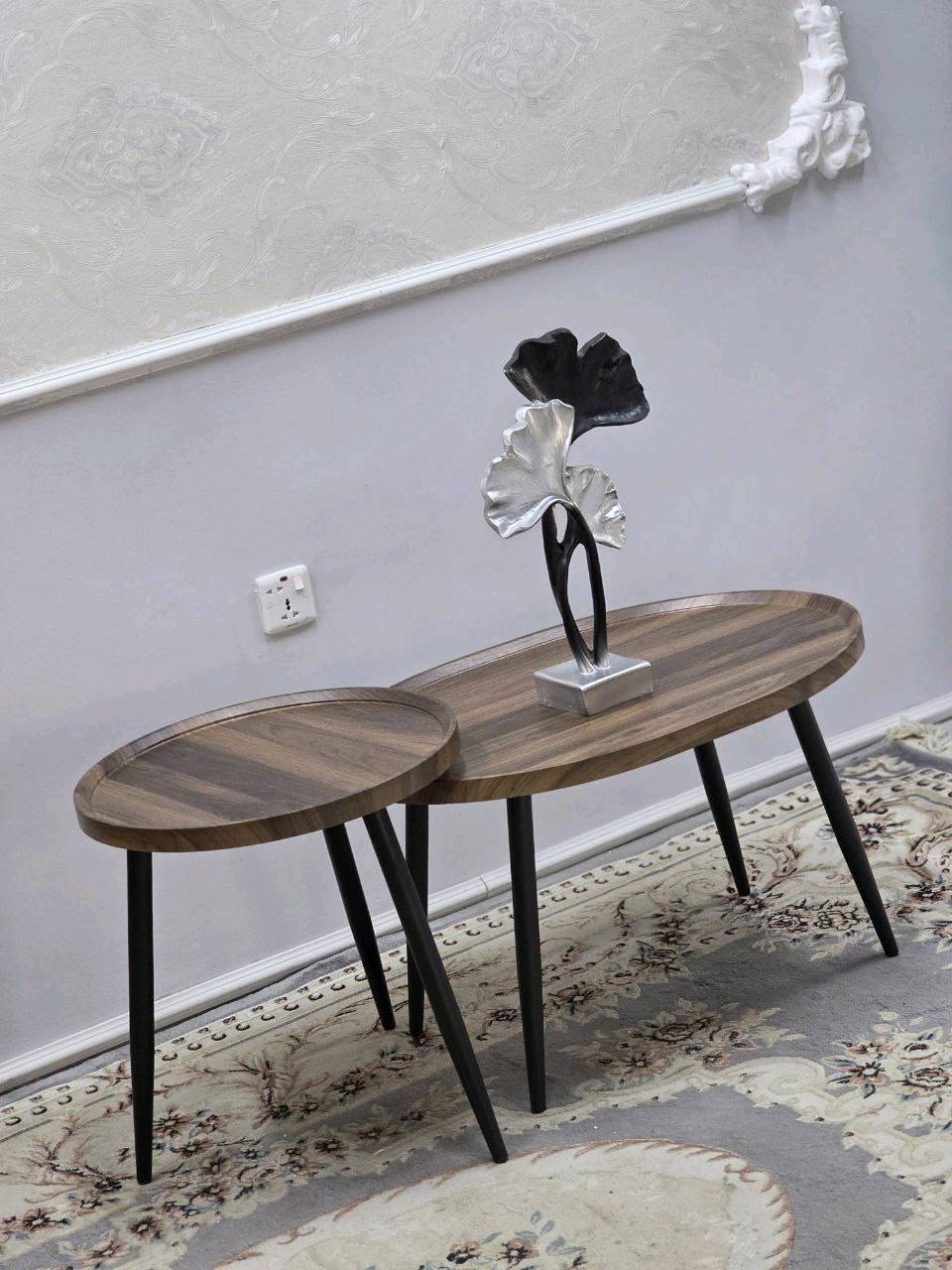 طقم طاولات جانبية مودرن وعصرية، بتصميم أنيق يجمع بين الخشب والمعدن، مما يضفي لمسة جمالية على أي مكان توضع فيه. تتوفر بألوان متعددة لتتناسب مع جميع الديكورات الداخلية. الطاولات متينة وسهلة التركيب، مثالية للاستخدام في غرف المعيشة أو كطاولات قهوة. يضاف للأسطوانة قطعة ديكور معدنية مميزة لتكتمل روعة التصميم.