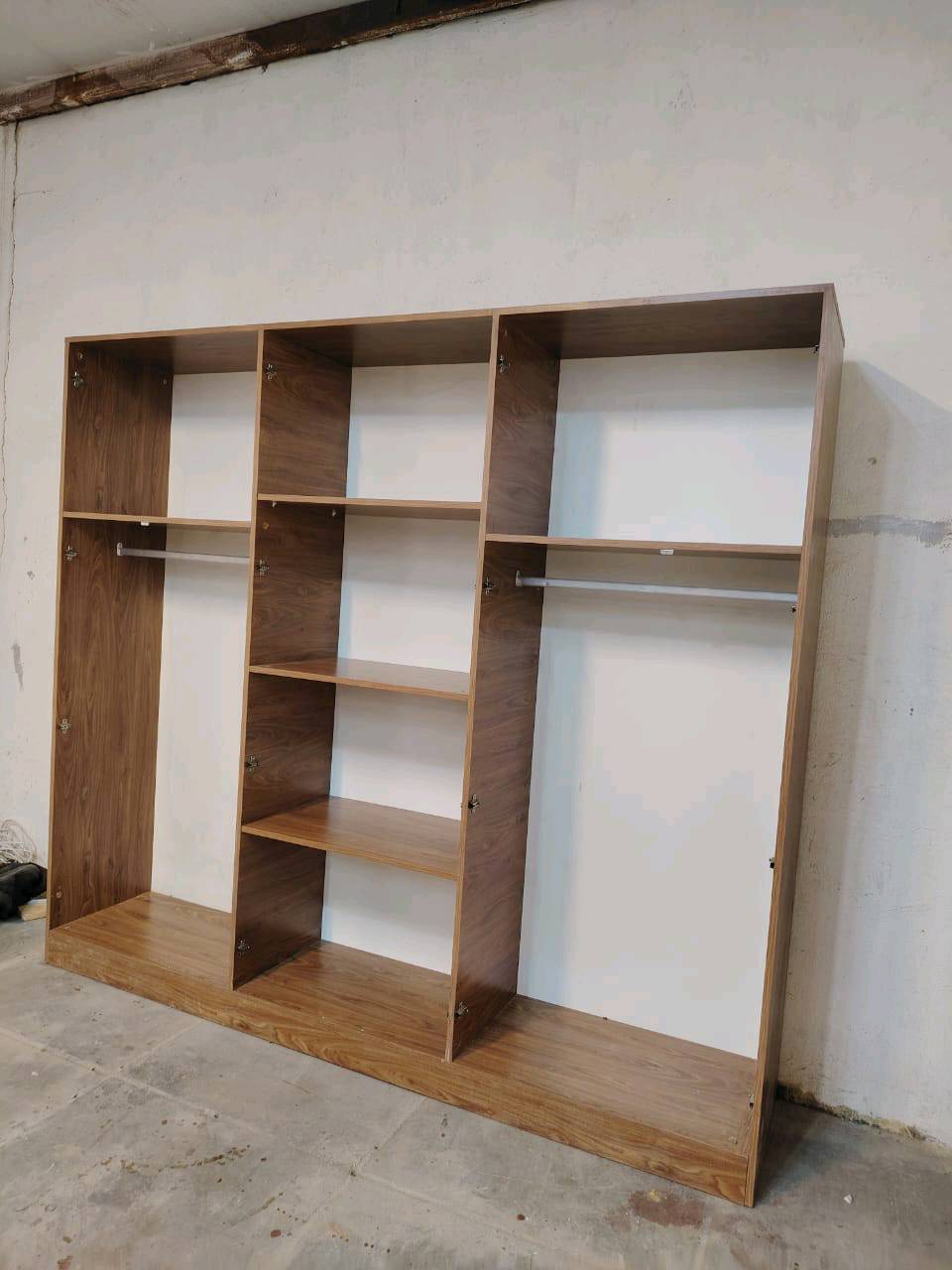 مجموعة غرفة نوم جديدة تحتوي على خزانات واسعة ومرآة وطاولة زينة مصنوعة من خشب متين. التصميم يجمع بين الأناقة والخطوط العصرية مع لمسات كلاسيكية. مثالية لإضفاء لمسة جمالية على غرفة النوم.