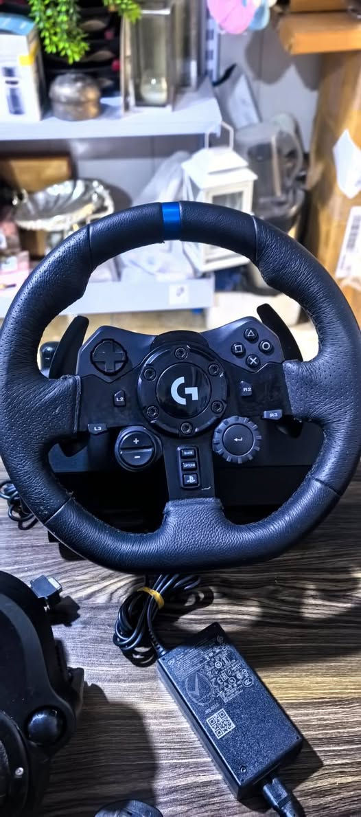 عجلة القيادة الاحترافية Logitech G923 Trueforce، وهي المخصصة لأجهزة PlayStation (PS4 / PS5) والكمبيوتر (PC) (ويتضح ذلك من تصميم الأزرار التي تحمل شعارات أسهم التوجيه وزر الـ PlayStation في الأسفل).إليك أبرز مواصفات ومميزات هذا الدركسون:⚙️ المواصفات والميزات الأساسيةتقنية TRUEFORCE: جيل جديد من نظام الاستجابة للاهتزاز (Force Feedback) يتزامن مباشرة مع فيزياء الألعاب ليعطيك شعوراً حقيقياً بالطريق، والمنعطفات، وهدير المحرك.درجة الدوران: يلتف حتى 900 درجة (لفتين ونصف) مثل سيارات السباق الحقيقية تماماً.التصميم والمواد: عجلة مكسوة بالجلد الطبيعي المخيط يدوياً، مع مبدلات سرعة (Shift Paddles) ومحور مركزي مصنوع من الألمنيوم المتين.مؤشر RPM: إضاءة LED مدمجة أعلى المقود تبين لك عدد دورات المحرك لتحديد الوقت المثالي لتبديل السرعات.محدد اختيار بـ 24 نقطة: قرص دوار مدمج يتيح لك تعديل قوة الفرامل، العزم، والاستقرار مباشرة أثناء القيادة.


**إذا كنت صاحب هذا الإعلان وتريد حذفه لأي سبب، رجاءا أرسل رسالة إلى الدعم الفني**