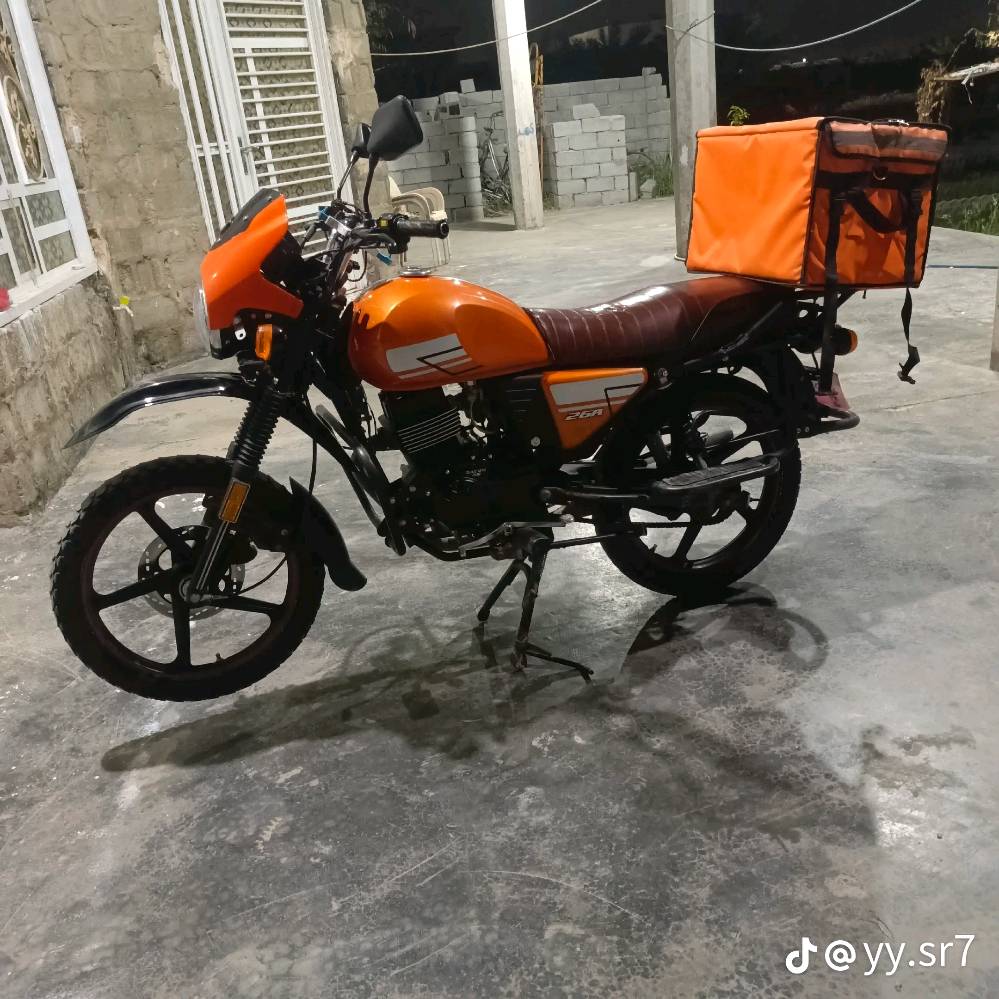 دراجة نارية برتقالية اللون بحالة جيدة جداً، مثالية للاستخدام اليومي والتنقل. تحتوي على حقيبة تخزين خلفية كبيرة، ممتازة لتوصيل الطرود أو استخدامات المتعددة. تمتاز بمقعد مريح وتصميم عصري. السعر منافس ومناسب لمن يبحث عن أداء عالي بأسعار معقولة.