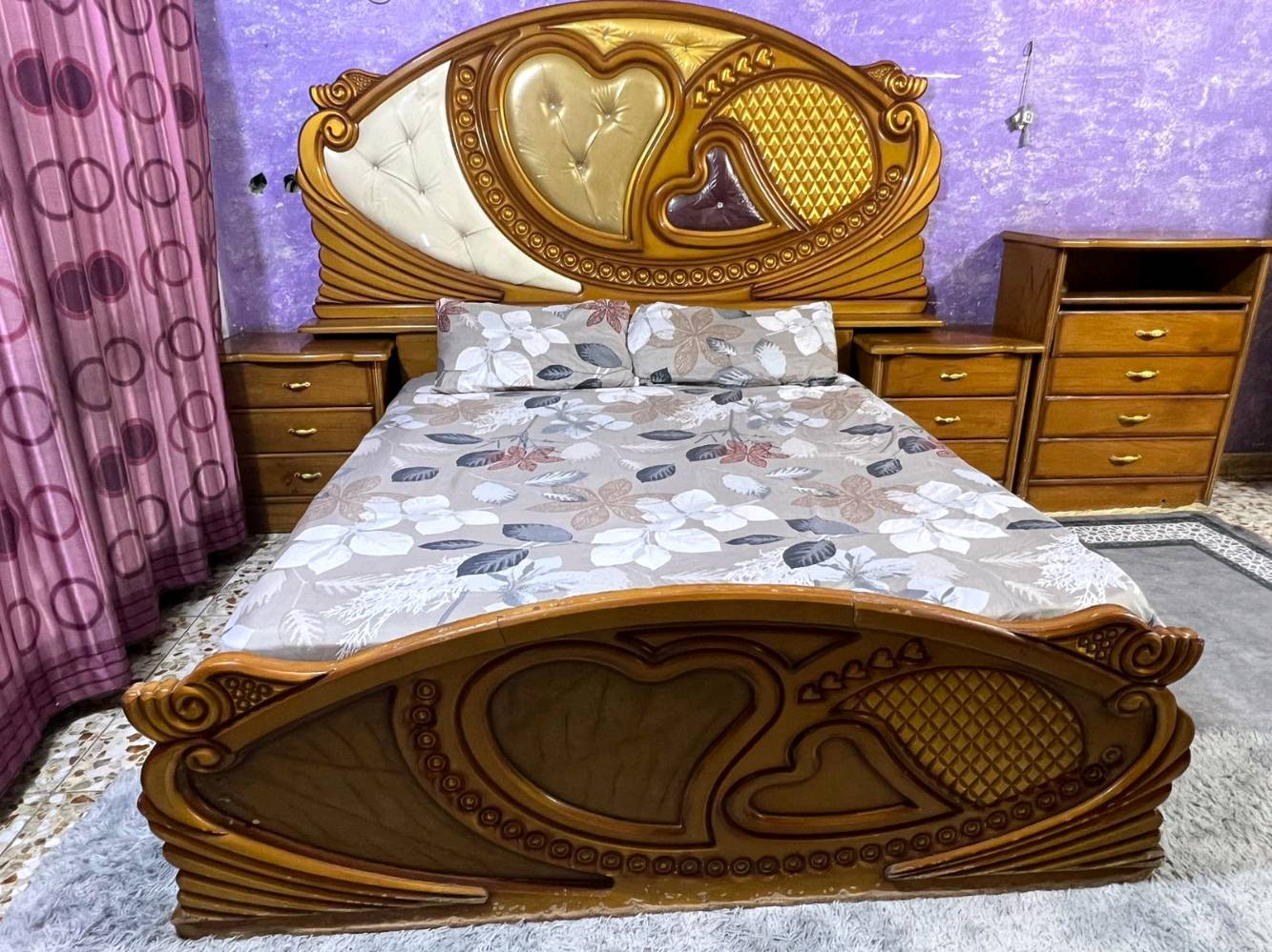 غرفة نوم خشبية أنيقة تتميز بالتصميم التقليدي والراقي مع نقوش قلبية جميلة على الخزانة والسرير. تحتوي على دولاب كبير مع مرايا أنيقة، بالإضافة إلى تسريحة مع مرآة واسعة تكمل جمال الغرفة. تُعد الغرفة مثالية لمن يحب الطراز الكلاسيكي وتناسب أي ديكور منزلي. حالة الخشب جيدة وتصميم الأثاث يضفي طابعاً مميزاً لأي غرفة نوم.