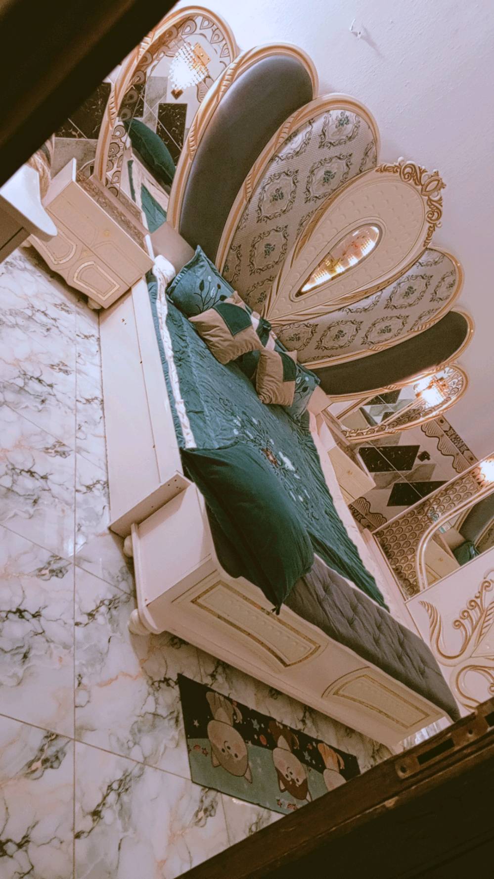 غرفة نوم مميزة بتصميم كلاسيكي فاخر، تتكون من سرير كبير ومريح مع لوح رأس ذو زخارف أنيقة ومرآة رائعة. الطقم يشمل أيضًا خزائن جانبية وتصميم فني على الجدران والخزائن. القطع مصنوعة بعناية لتضيف لمسة من الفخامة لأي غرفة نوم.