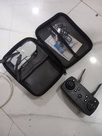 تظهر في الصورة طائرة بدون طيار (درون) من طراز E88 Pro أو E99 Max داخل ...