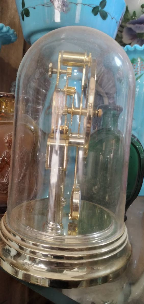 ***********
ساعة طاولة عتيقة من طراز Kundo Quartz Torsion، وتتميز بغطاء زجاجي واقٍ.تحتوي الساعة على حركة مرئية تعمل بالبطارية، مع قرص ذو أرقام رومانية وشعار  ريذم
