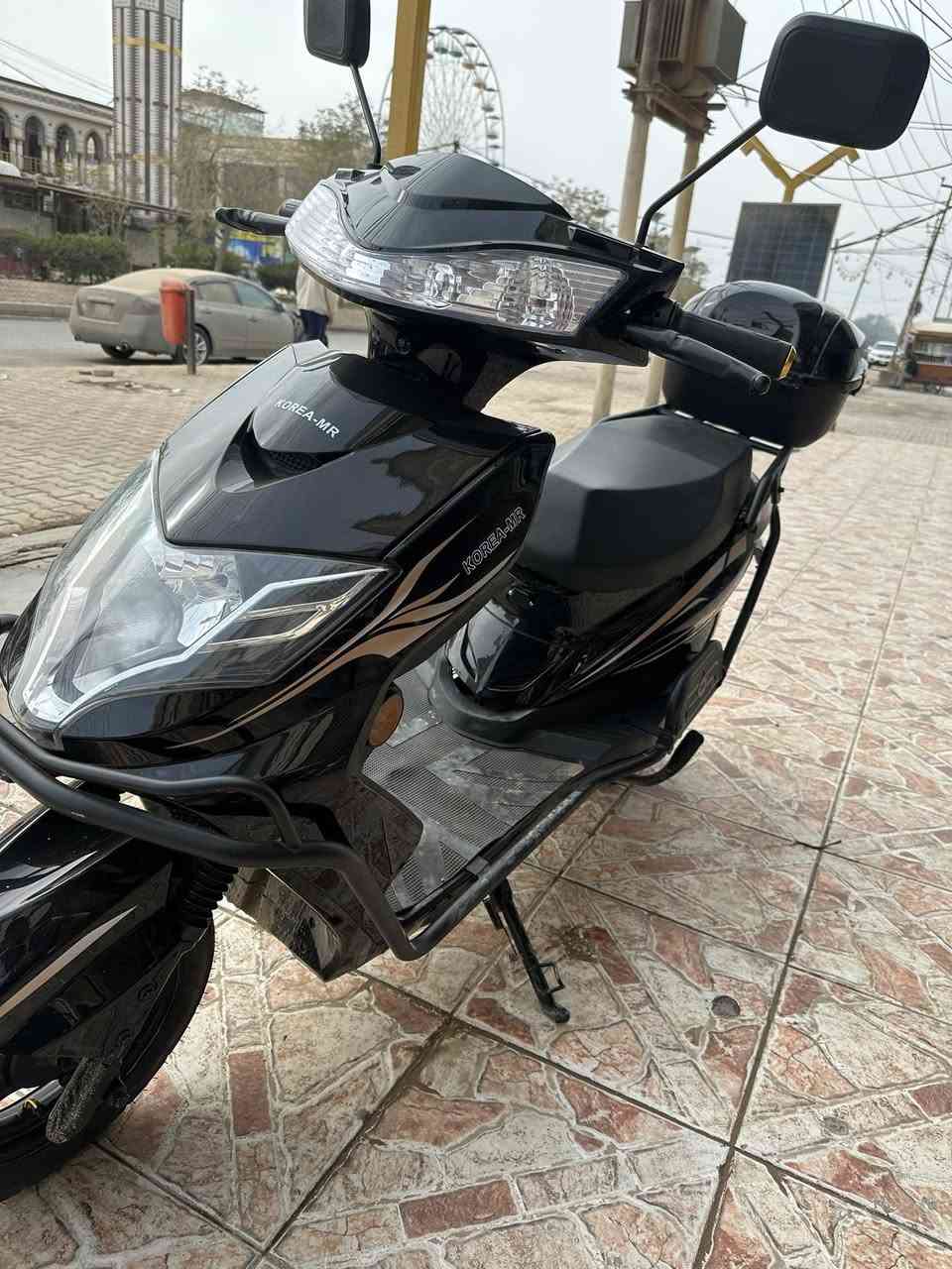 🔹 النوع
سكوتر كهربائي ( KOREA-MR ) 
مناسب للمشاوير القريبة والتنقل اليومي
🔹 التصميم
لون أسود لامع مع خطوط جانبية أنيقة
تصميم انسيابي وشبابي
مرايات جانبية عريضة للرؤية الواضحة
مصباح أمامي كبير LED يعطي إنارة قوية بالليل
مسند قدم واسع ومريح
🔹 المواصفات المتوقعة (تقريبية حسب هذا النوع)
⚡ المحرك: كهربائي (عادة 800 – 1500 واط)
🔋 البطارية: غالبًا رصاص جل
⏱️ الشحن: 6 – 8 ساعات تقريبًا
🚀 السرعة القصوى: 40 – 50 كم/س
📏 المدى: 40 – 60 كم بالشحنة الواحدة
🪑 الحمولة: شخص أو شخصين (حدود 150–180 كغم)
🔹 الأمان والراحة
فرامل أمامية وخلفية
إشارة يمين ويسار.                              ملاحضه موديل 2025
ضوء خلفي + ضوء توقف.                   صارلي شهر من مآخذه 
قاعدة جانبية + وسطية
مقعد مريح وارتفاعه مناسب
🔹 المميزات
ما يحتاج بنزين ⛽
هادئ جدًا
اقتصادي (شحنه أرخص هواي من البنزين)
سهل الاستخدام  تواصل ***********
