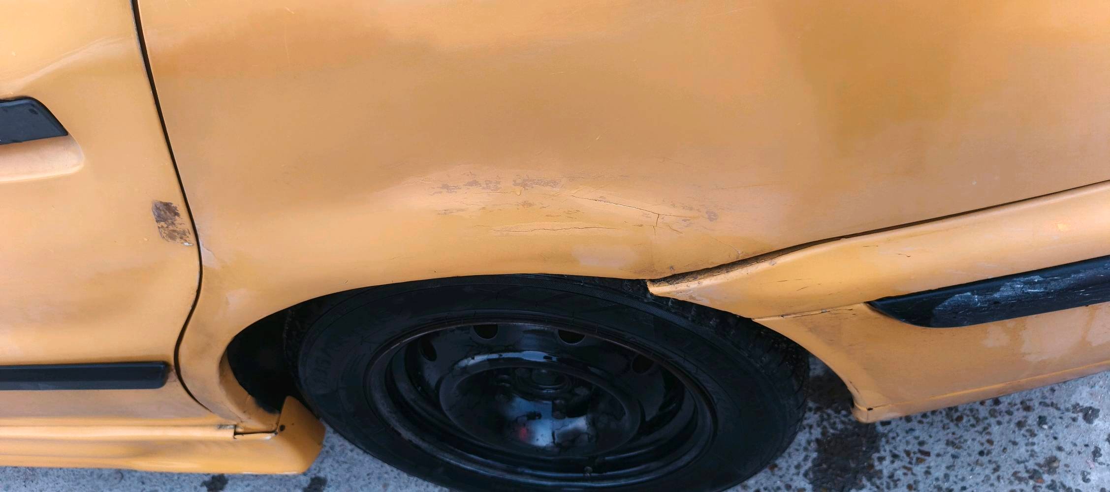 سيارة صالون صفراء، داخلية واسعة وعجلة قيادة مغطاة للراحة. الجنوط باللون الأسود لإضافة لمسة من الأناقة. السيارة مناسبة للاستخدام اليومي. موثوقة للأسر والجولات داخل المدينة.