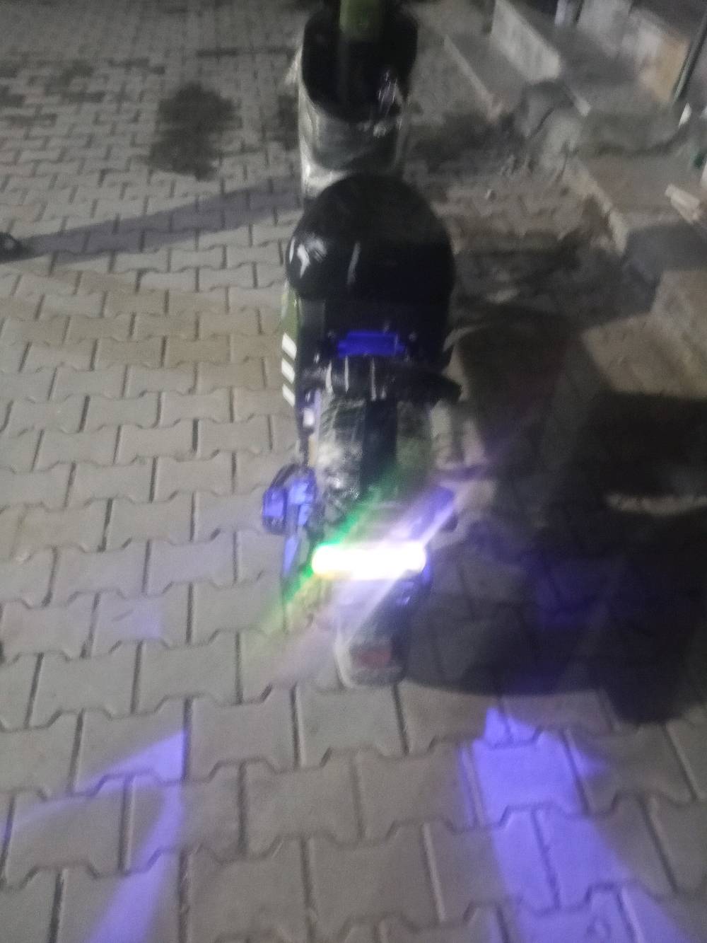 دراجة كهربائية حديثة، مزودة بأضواء ليد لإضاءة مميزة ليلاً. شاشة العرض توضح السرعة ومستوى البطارية. حالة الدراجة ممتازة وجديدة تماماً، مثالية للتنقل اليومي الاقتصادي والسريع داخل المدينة.