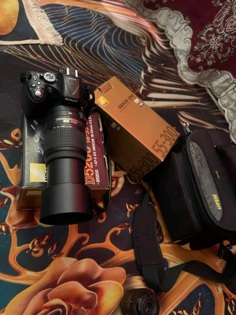 كامرة نيكون d5200 وياها عدستين 18.55 وعدسة 70.300 شتر 19 رايدها 450 وبيها مجال مكاني بغداد