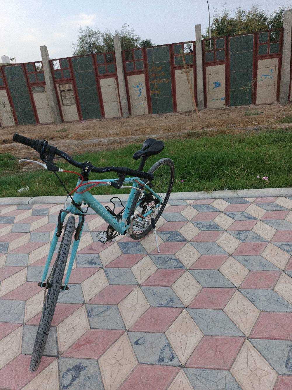 بايسكل رياضي معاصر ولونه أزرق فاتح، في حالة جيدة ومناسب للرحلات اليومية. يتضمن مقعد مريح ومقود سهل التحكم. مثالي للياقة البدنية أو التنقل السريع داخل المدينة. تصميمه عملي ومناسب لجميع الأعمار.