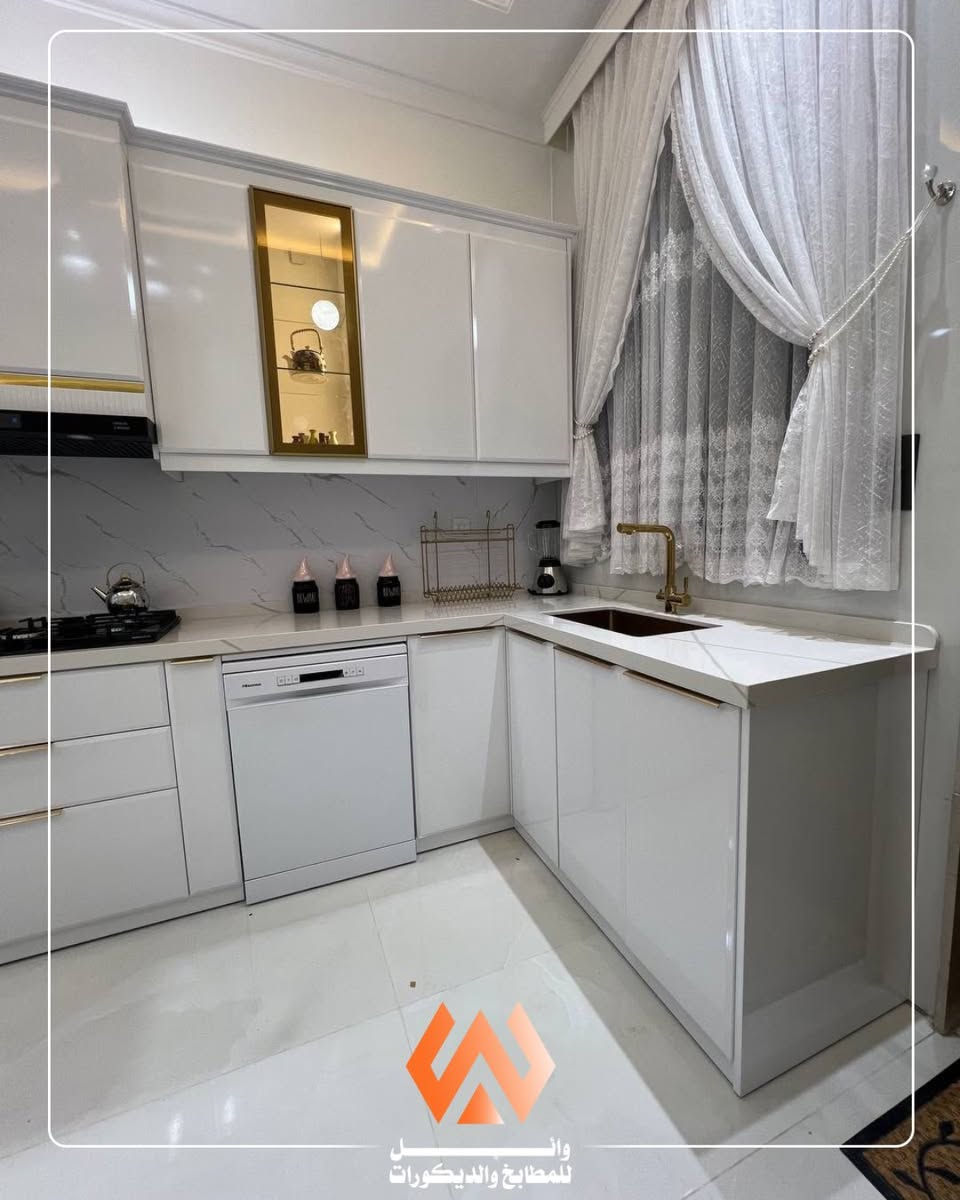 ✨ هل تبحث عن مطبخ يجمع بين الفخامة والهدوء في تصميم واحد؟ ✨
من أعمال وائل للمطابخ والديكورات نقدم لكم هذا المطبخ العصري الأنيق الذي صُمم بعناية ليمنح المنزل لمسة من الرقي والراحة.

يتميز المطبخ بلونه الأبيض الهادئ الذي يعكس الإضاءة ويمنح المكان إحساساً بالاتساع والنظافة، مع تفاصيل ذهبية أنيقة في المقابض والإكسسوارات تضيف لمسة فاخرة دون مبالغة. كما تم اعتماد تصميم حرف (L) لاستغلال المساحة بأفضل صورة وتوفير حركة مريحة أثناء الاستخدام.

🔹 خزائن علوية وسفلية بتصميم عصري وخطوط انسيابية
🔹 أسطح عمل واسعة بتشطيب راقٍ وسهلة التنظيف
🔹 إضاءة مخفية داخل السقف تمنح أجواءً دافئة ومميزة
🔹 وحدة عرض زجاجية مضاءة تضيف لمسة فخامة للتصميم
🔹 تناغم أنيق بين اللون الأبيض والتفاصيل الذهبية
🔹 توزيع عملي للأجهزة ومساحات التخزين لراحة أكبر
🔹 تشطيبات دقيقة وخامات عالية الجودة تضمن المتانة والجمال

لأن المطبخ هو قلب المنزل، نحرص في وائل للمطابخ والديكورات على تقديم تصاميم تجمع بين الجمال العملي والفخامة العصرية لتبقى مميزة لسنوات طويلة.

📞 للتصميم، التنفيذ، أو الاستفسار:
*********** - ***********

📍 الأنبار – الفلوجة، حي الجمهورية قرب معمل إسفنج الفلوجة

