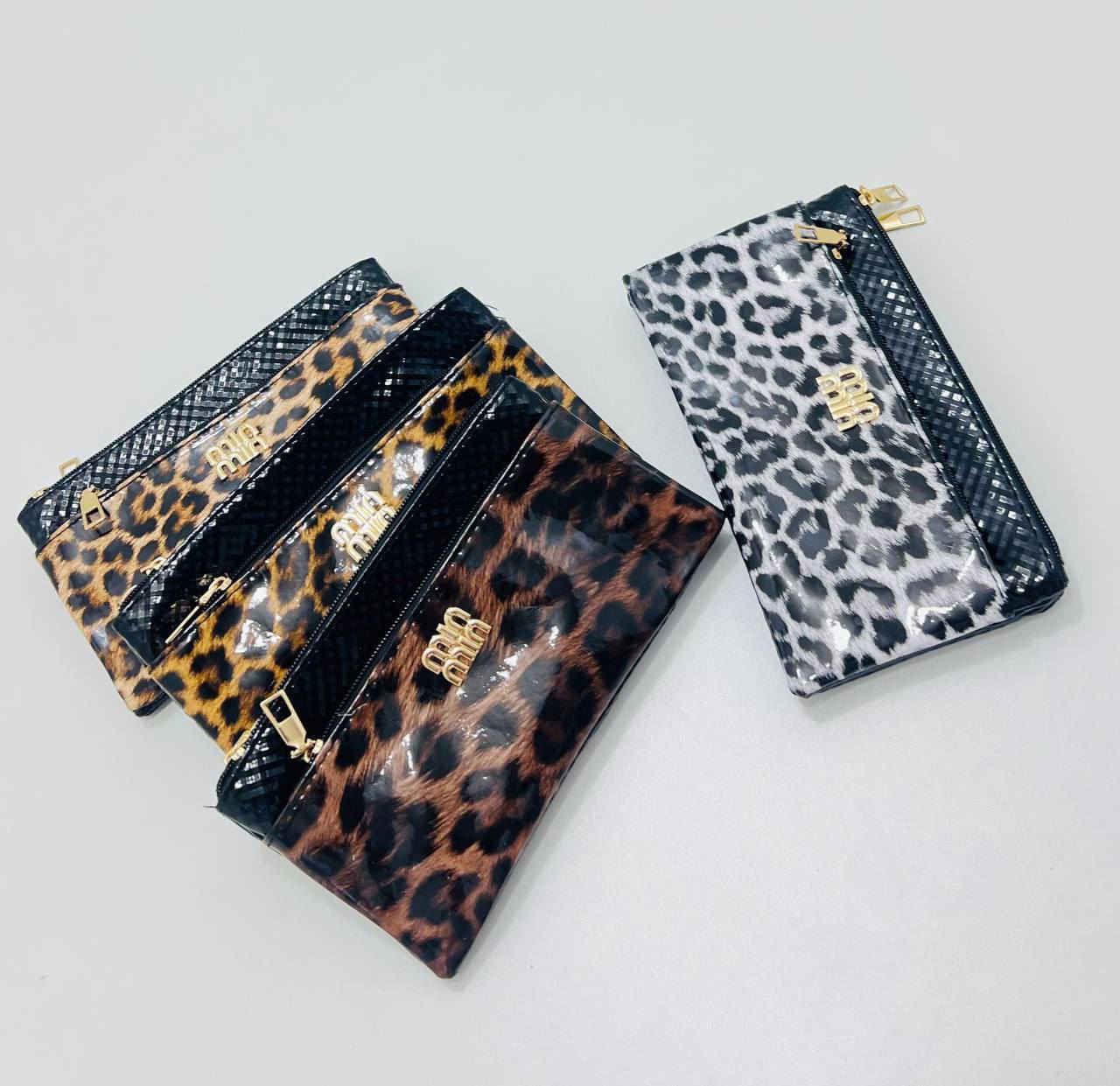 حقيبة كلاتش (Clutch) بنقشة جلد النمر. 
تتميز الحقيبة بالتالي:
التصميم: تأتي بنقشة جلد النمر (Leopard Print) باللونين الأبيض والأسود، مع جزء علوي أسود اللون.
الشعار: يتوسطها شعار ذهبي بارز.
الإغلاق: مزودة بسحاب علوي باللون الذهبي.
الاستخدام: تُستخدم عادةً كحقيبة يد صغيرة للمناسبات أو كحقيبة لتنظيم المكياج والمقتنيات الصغيرة داخل حقيبة أكبر.


**إذا كنت صاحب هذا الإعلان وتريد حذفه لأي سبب، رجاءا أرسل رسالة إلى الدعم الفني**
