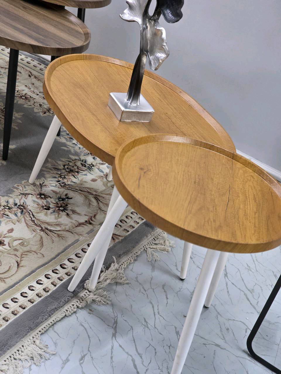 طقم طاولات جانبية مودرن وعصرية، بتصميم أنيق يجمع بين الخشب والمعدن، مما يضفي لمسة جمالية على أي مكان توضع فيه. تتوفر بألوان متعددة لتتناسب مع جميع الديكورات الداخلية. الطاولات متينة وسهلة التركيب، مثالية للاستخدام في غرف المعيشة أو كطاولات قهوة. يضاف للأسطوانة قطعة ديكور معدنية مميزة لتكتمل روعة التصميم.