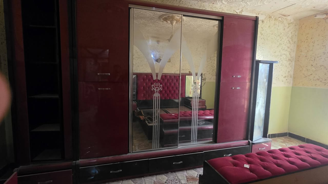 الغرفة الاولى ..
غرفة نوم مودرن فخمة للبيع بحالة ممتازة - عنابي وأسود ملكي 👑
​دولاب ملابس كبير جداً: أبواب سحاب (سلايد) موفرة للمساحة، مع مرايا كبيرة في المنتصف منقوشة بالليزر. يحتوي على أرفف مكشوفة جانبية للعرض 
​سرير مزدوج: مع خلفية (تاج) منجدة بالكامل قماش مخملي كابيتونيه (Tufte) باللون العنابي الجذاب، مريحة جداً وشيك
​2 كمدينو: مدمجين مع تصميم السرير، يحتويان على أدراج (بحاجة لتركيب مقابض لبعض الأدراج).
​تسريحة (بيرو): مرآة كبيرة ببرواز عنابي لامع، مع أدراج واسعة لتخزين المكياج والأغراض
​بوف (مقعد): منجد كابيتونيه نفس خامة خلفية السرير، يوضع أمام السرير أو التسريحة.
​الحالة: الغرفة نظيفة ومستعملة استعمال حشمة، الخشب متين، وبحالة عامة جيدة جداً (كما هو واضح في الصور).
​🔹 السعر المطلـوب: [مليونين] (قابل للتفاوض البسيط)
🔹 الموقع/العنوان: [خلف المجمع الطبي]
🔹 النقل والفك: على المشتري.
للتواصل والاستفسار، يرجى إرسال رسالة خاصة أو الاتصال على الرقم: [***********]

الغرفة الثانية 
للراغبين في المتانة والمساحات الكبيرة، معروض للبيع غرفة نوم كلاسيكية من الخشب المتين (طراز قديم ولكنه يعيش طويلاً). الغرفة لون خشب بني طبيعي.
دولاب ملابس ضخم  4 أبواب كبيرة، مع أدراج سفلية في المنتصف ومرآة صغيرة. مساحته واسعة جداً من الداخل.
​تسريحة كبيرة  مرآة بيضاوية كبيرة كلاسيكية، وعدد كبير من الأدراج والخزائن السفلية.
​خزانة إضافية: تظهر بجانب التسريحة يمكن استخدامها ككمدينو كبير أو خزانة أدراج إضافية.
​شماعة ملابس خشبية.
​الحالة: الغرفة قديمة ومستعملة، الخشب بحالة جيدة ومتين ولكنه يحتاج لتنظيف وتلميع وقد يحتاج لبعض الإصلاحات البسيطة لضبط الأدراج. (البيع بدون الأغراض الظاهرة فوق الأثاث وبدون الساعة). الغرفة تباع كما هي في الصور.
​الغرفة مناسبة جداً لمن يبحث عن توفير مساحة تخزين كبيرة في شقة مفروشة، سكن عمال، أو منزل ريفي بسعر اقتصادي.
​🔹 السعر المطلـوب: [500] (لقطة للمستعجل)
🔹 الموقع/العنوان: [خلف المجمع الطبي]
🔹 النقل والفك: على المشتري.
​للتواصل: [***********]
