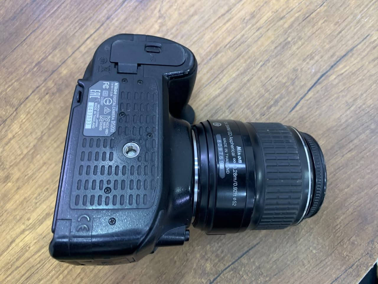 كاميرا Nikon D5200 هي واحدة من أشهر كاميرات DSLR للفئة المبتدئة والمقارب للمتوسطة التي قدمتها نيكون. على الرغم من إصدارها قبل عدة سنوات، إلا أنها لا تزال تقدم أداءً ممتازاً جداً بفضل مستشعرها القوي ومعالج الصور الخاص بها.
إليك المواصفات الكاملة والتفصيلية لكاميرا Nikon D5200:
📷 المواصفات الأساسية (Core Specs)
 * نوع الكاميرا: DSLR (بمرآة).
 * المستشعر (Sensor): من نوع CMOS بحجم APS-C (DX format).
 * دقة المستشعر: 24.1 ميجابكسل (تمنحك صوراً عالية الدقة وقابلة للاقتصاص والتكبير بوضوح ممتاز).
 * معالج الصور: EXPEED 3 (يساعد على معالجة الألوان بسرعة وتقليل الضوضاء "الـ Noise").
⚡ الأداء والسرعة
 * سرعة التصوير المتتابع (Continuous Shooting): تصل إلى 5 إطارات في الثانية (Fps)، وهي مناسبة لتصوير الحركة السريعة أو الأطفال والحيوانات الأليفة.
 * حساسية الضوء (ISO): تبدأ من 100 وتصل إلى 6400 (يمكن توسيعها رقمياً لتصل إلى 25600). أداؤها ممتاز في الإضاءة المنخفضة مقارنة بجيلها.
 * نظام التركيز التلقائي (Autofocus): يحتوي على 39 نقطة تركيز (منها 9 نقاط من النوع التصالبي Cross-type لزيادة الدقة)، وهو نظام تركيز قوي جداً ورثته من شقيقتها الأكبر D7000.
🎥 تصوير الفيديو (Video Capabilities)
 * دقة الفيديو: تصوير بجودة Full HD (1080p) بسرعة 60i أو 30p/24p إطار في الثانية.
 * الميكروفون: ميكروفون ستيريو مدمج (Stereo Mic) بفتحات أعلى الكاميرا لتسجيل صوت نقي، بالإضافة إلى منفذ ميكروفون خارجي (3.5mm) لمحترفي الصوت.
🖥️ الشاشة والتصميم
 * الشاشة: شاشة بمقاس 3.0 إنش قابلة للإمالة والتدوير بالكامل (Vari-angle)، وهي ممتازة جداً لالتقاط الصور من زوايا صعبة، أو لتصوير الفلوقات وصناعة المحتوى الشخصي.
 * دقة الشاشة: 921,000 نقطة (تمنحك وضوحاً ممتازاً لمعاينة الصور).
 * محدد الرؤية (Finder): محدد رؤية بصري (Pentamirror) يغطي حوالي 95% من الكادر.
🔋 البطارية والتوصيل
 * البطارية: من نوع EN-EL14، تكفي لالتقاط حوالي 500 صورة تقريباً بالشحنة الواحدة (حسب ظروف الاستخدام).
 * الاتصال: لا تحتوي على واي فاي مدمج (Wi-Fi)، ولكن يمكن توصيلها بقطعة خارجية (WU-1a) لنقل الصور لاسلكياً، وتدعم منافذ USB و HDMI.
> 💡 ملاحظة للمشتري:
> كاميرا Nikon D5200 لا تحتوي على محرك تركيز داخلي (Focus Motor) في جسم الكاميرا. هذا يعني أنه لتشغيل التركيز التلقائي (Autofocus)، يجب عليك استخدام عدسات نيكون التي تحتوي على محرك مدمج (والتي تحمل الرمز AF-S أو AF-P)، أما العدسات القديمة الـ (AF) فستعمل عليها بالتركيز اليدوي فقط.
>
الاستفسار الاتصال على. رقم***********@
