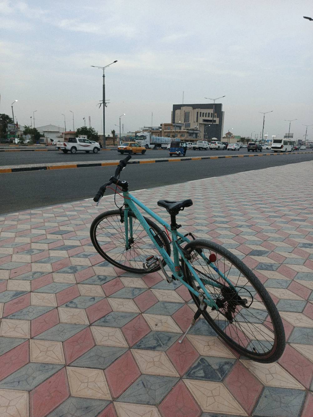 بايسكل رياضي معاصر ولونه أزرق فاتح، في حالة جيدة ومناسب للرحلات اليومية. يتضمن مقعد مريح ومقود سهل التحكم. مثالي للياقة البدنية أو التنقل السريع داخل المدينة. تصميمه عملي ومناسب لجميع الأعمار.