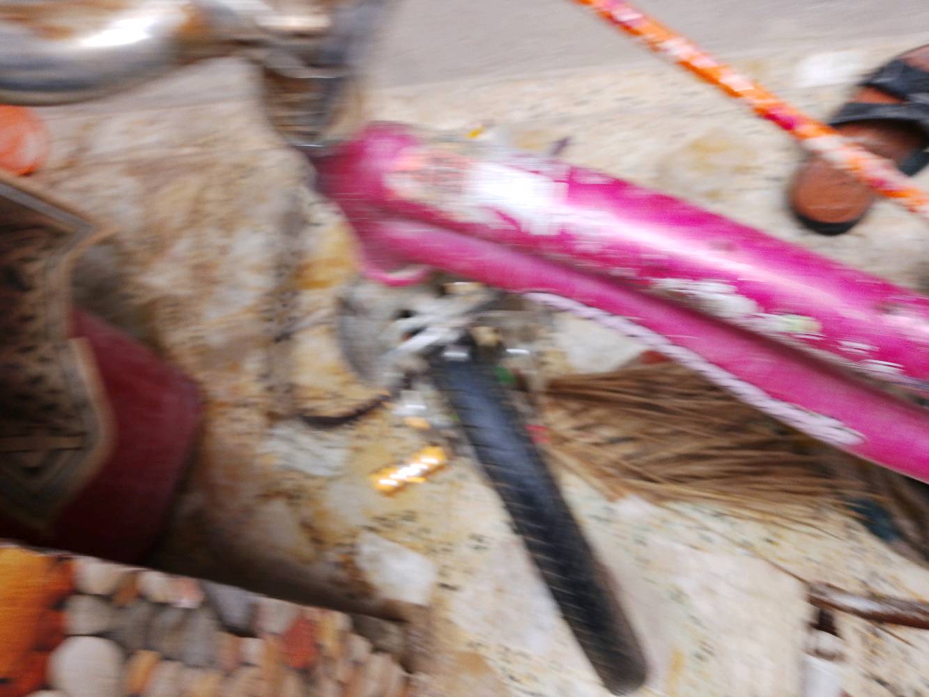 دراجة هوائية بلون وردي مناسبة للأطفال، فيها زينة ملونة على العجلات. تحتاج إلى بعض التنظيف والصيانة. خيار ممتاز للتمتع بركوب الدراجات في الأماكن المفتوحة.