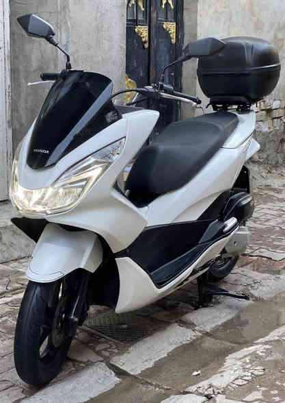 السلام عليكم للبيع 
دراجة pcx 2017 جيل ثاني ام لد 
ياباني اصلي طك كارتون ع وضع رمبة 
رقم الشاصي JF56 - 1025990

لون ابيض صدفي 
عداد المسافة 19 الف حقيقي 
حجم المحرك 125cc 
جنطة + قاعده + سيباية كلهن اصليات 
سويجات عدد 2 للجنطة وللدراجة 
حساس زدحام + ستان كهربائي 
دبل اشارة 
تايرات خلفي امامي بخط شركة 
اوراقة شغلاته كله كاملة 
الدراجة بشهر 8 طالعه من كلشي وكلاشي 
ع وضع رمبة جديده بمعنى الكلام 
كفالة محرك كفرات كهربائيات شرط 
الفحص وين ميعجبك وين متريد 
تاخذه من باب بيت 

اي ستفسار خاص او واتساب 
رقمي *********** 

العنوان النهظة شارع شيخ عمر 
قرب باجة الحاتي

