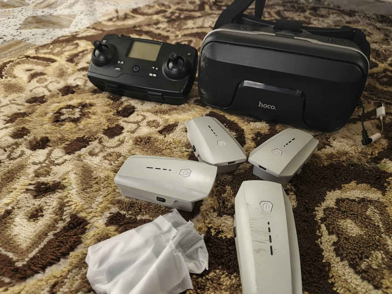 اسلام عليكم
بناءً على الصورة والبحث، هذه هي طائرة الدرون KF102 (أو KF102 MAX)، وهي طائرة قابلة للطي مزودة بنظام تحديد المواقع (GPS) وكاميرا بدقة 4K مثبتة على جيمبال (محور استقرار) ثنائي المحاور. 
المكونات والملحقات الظاهرة في الصورة:
طائرة الدرون: جسم الطائرة القابل للطي في الجهة اليمنى.
جهاز التحكم عن بعد: مزود بشاشة LCD لعرض بيانات الرحلة وحامل للهاتف الذكي.
نظارات VR (الواقع الافتراضي): نظارات FPV سوداء تتيح لك رؤية ما تصوره الكاميرا وكأنك داخل الطائرة.
البطاريات: يظهر في الصورة 3 بطاريات إضافية (7.4 فولت، 2200 مللي أمبير)، مما يطيل وقت الطيران الإجمالي.
حقيبة التخزين: حقيبة مخصصة لحماية الطائرة وملحقاتها وسهولة نقلها. 
أبرز المواصفات والمميزات:
التصوير: كاميرا 4K مع محور استقرار ثنائي المحاور لتقليل الاهتزاز وضمان فيديو سلس.
نظام الطيران: محركات "برشلس" (Brushless) قوية ومقاومة للرياح، مع مدى تحكم يصل إلى 800-1200 متر.
وقت الطيران: تستمر البطارية الواحدة لحوالي 22-25 دقيقة.
ميزات ذكية: تدعم "العودة التلقائية" عند انخفاض البطارية، "المتابعة الذكية" (Follow Me)، والطيران عبر مسار محدد مسبقاً على الخريطة.
تجنب العوائق: إصدار KF102 MAX قد يحتوي على مستشعر لتجنب العوائق بزاوية 360 درجة.


**إذا كنت صاحب هذا الإعلان وتريد حذفه لأي سبب، رجاءا أرسل رسالة إلى الدعم الفني**