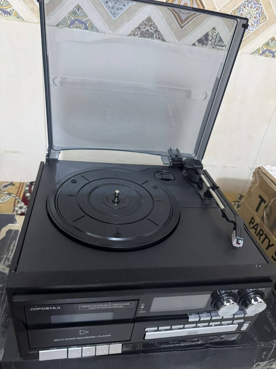 الجهاز هو نظام موسيقي متعدد الاستخدامات يحمل العلامة التجارية Jopostar. 
متعدد الوظائف: يشتمل على مشغل أسطوانات فينيل بثلاث سرعات، ومشغل أقراص مضغوطة (CD)، ومشغل أشرطة كاسيت. 
الاتصال اللاسلكي: يدعم تقنية البلوتوث لتشغيل الموسيقى من الهواتف الذكية أو الأجهزة الأخرى. 
الوسائط الرقمية: يحتوي على منفذ USB وفتحة لبطاقة SD لتشغيل الملفات الرقمية وتسجيل الموسيقى. 
راديو مدمج: يأتي مع موالف راديو AM/FM للاستماع إلى البث المباشر.


**إذا كنت صاحب هذا الإعلان وتريد حذفه لأي سبب، رجاءا أرسل رسالة إلى الدعم الفني**