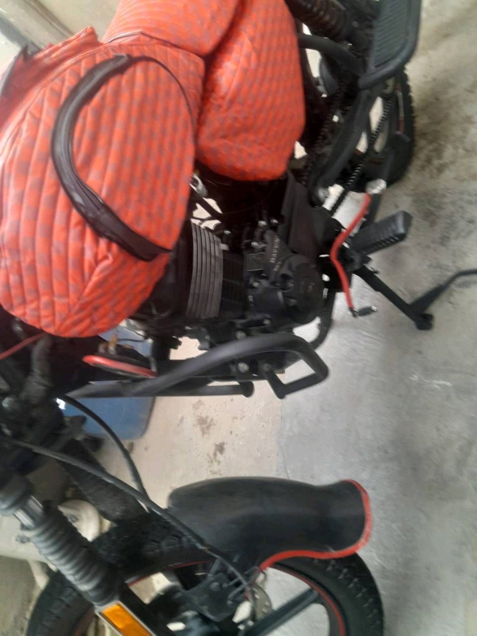درّاجة نارية نوع دايون مع غطاء برتقالي خاص للتنجيد لمحافظة على المقاعد. بحالة ممتازة، مثالية للتنقل داخل المدينة والرحلات اليومية. العداد يظهر 23666 كيلومتر. متوفرة في بغداد وجاهزة للاستخدام المباشر.
