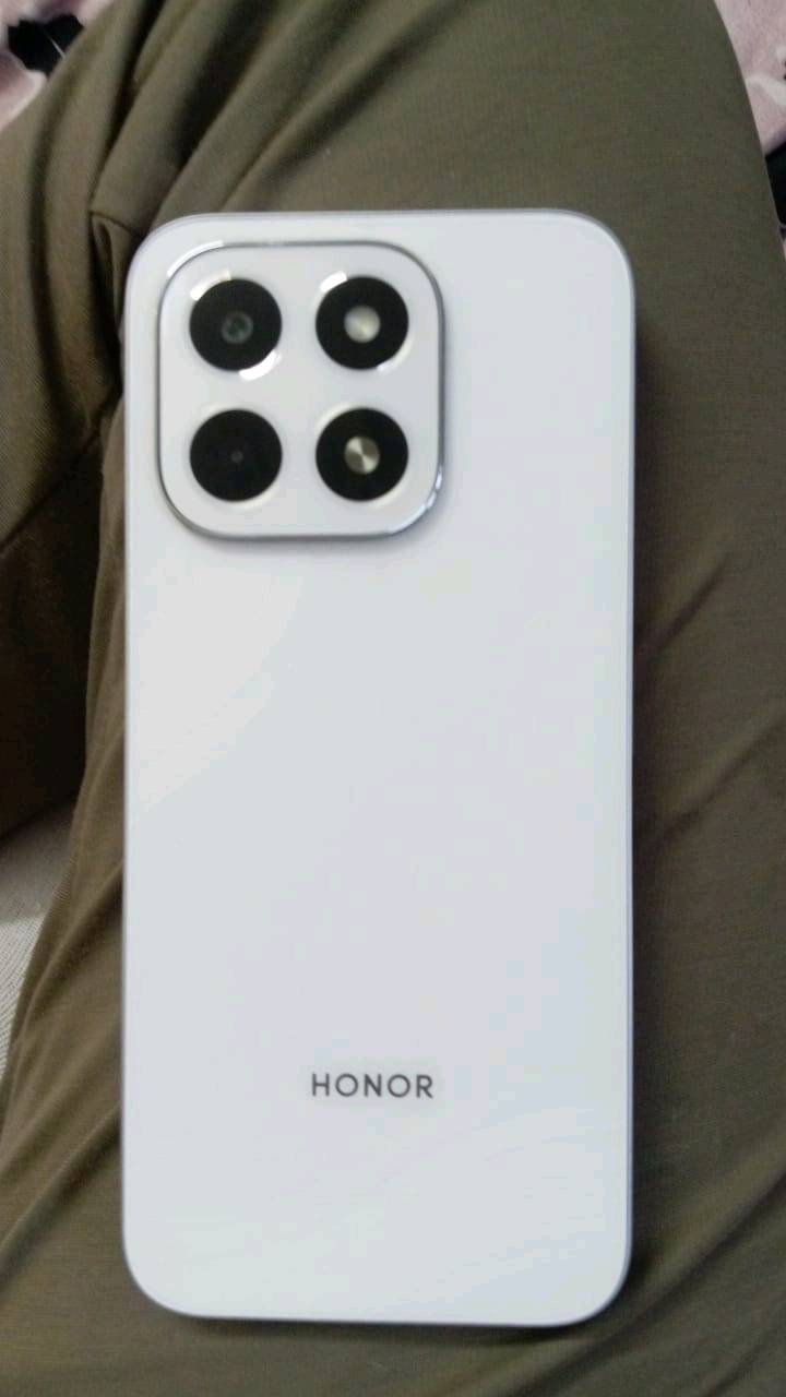 تليفون Honor X6C جديد وغير مستخدم، بلونه الأبيض الأنيق. الجهاز يحتوي على ثلاث كاميرات خلفية مما يضمن لك تصوير احترافي بصور نقية. العلبة وجميع الملحقات موجودة. يتميز الجهاز بتصميمه العصري والرفيع مما يجعله سهل الحمل والاستخدام اليومي.