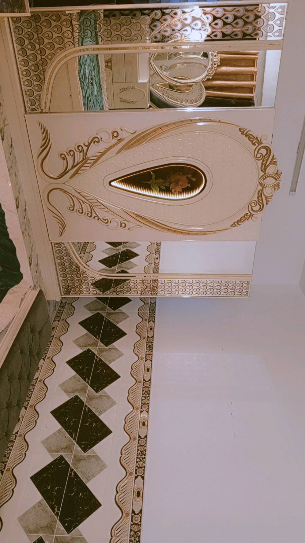 غرفة نوم مميزة بتصميم كلاسيكي فاخر، تتكون من سرير كبير ومريح مع لوح رأس ذو زخارف أنيقة ومرآة رائعة. الطقم يشمل أيضًا خزائن جانبية وتصميم فني على الجدران والخزائن. القطع مصنوعة بعناية لتضيف لمسة من الفخامة لأي غرفة نوم.