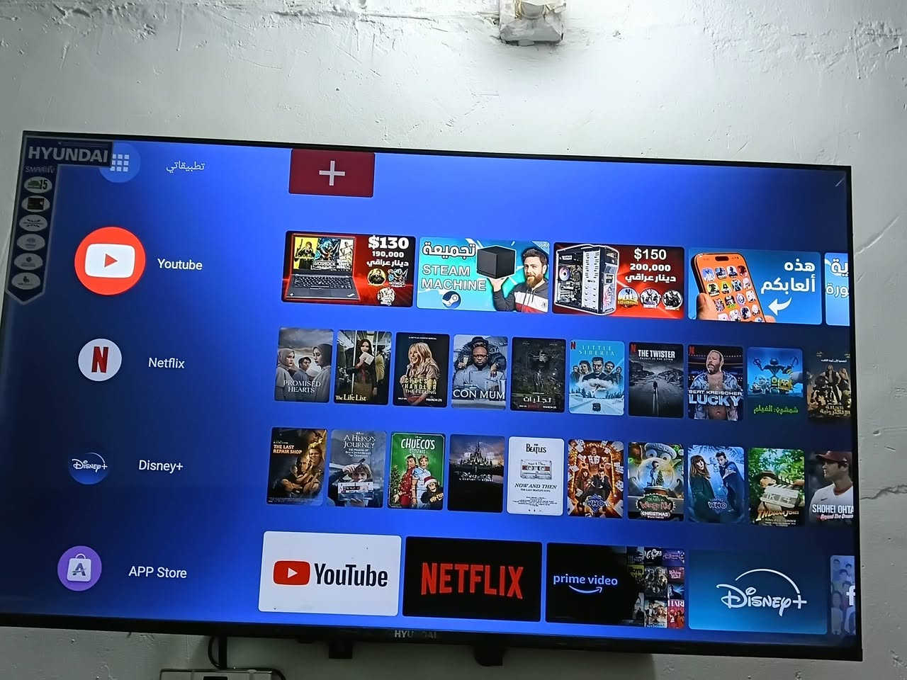 هذه الشاشة هي من نوع هيونداي (Hyundai)، وتعمل بنظام تشغيل ذكي (Smart TV) يتيح لك تشغيل تطبيقات البث ومشاركة محتوى الإنترنت.
إليك أهم ما يظهر بخصوص مواصفاتها من الصورة:
​النظام والواجهة: تدعم اللغة العربية وتحتوي على متجر تطبيقات خاص بها لخدمات البث المعروفة.
​التطبيقات المثبتة: يتوفر عليها بشكل مسبق تطبيقات أساسية مثل:
​يوتيوب (YouTube)   ***********
​نتفليكس (Netflix)
​ديزني بلس (+Disney)
​أمازون برايم فيديو (Prime Video)
​متجر تطبيقات (App Store) لتنزيل برامج إضافية.
​إذا كنت تبحث عن رقم الموديل الدقيق (الرمز الخاص بالشاشة)، فغالباً ستجده مطبوعاً على ملصق أبيض أو أسود خلف الشاشة نفسها، ويحتوي على أحرف وأرقام تحدد حجم الشاشة وسنة تصنيعها بدقة.
هذه الشاشة هي من نوع هيونداي (Hyundai)، وتعمل بنظام تشغيل ذكي (Smart TV) يتيح لك تشغيل تطبيقات البث ومشاركة محتوى الإنترنت.
