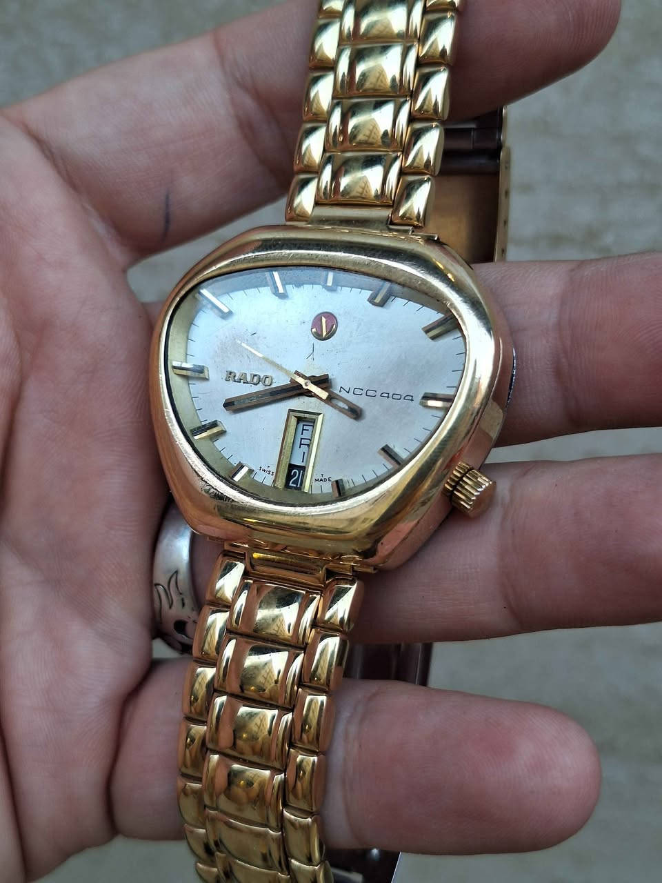 ساعة Rado NCC 404 السويسرية الكلاسيكية، والمعروفة بين الهواة والمجمعين باسم "Rado Cobra" نظراً لشكل هيكلها الفريد غير المتماثل الذي يشبه رأس أفعى الكوبرا.تنتمي هذه الساعة إلى سلسلة "NCC" (اختصار لـ New Case Concept) التي أطلقتها شركة رادو السويسرية في أواخر الستينيات وبداية السبعينيات لتجربة تصاميم وهياكل هندسية مبتكرة ومقاومة للصدمات والماء بشكل متطور في وقتها.أبرز مواصفات ومميزات الساعة:التصميم والهيكل: تأتي بهيكل فريد ومطلي بالذهب. يتميز التصميم بغياب العروات التقليدية (Lugs) مما يجعلها مريحة جداً على المعصم رغم حجمها البارز.المينا (Dial): باللون الفضي/الذهبي الفاتح مع مؤشرات بارزة ثلاثية الأبعاد (Baton Indices) وعقارب ذهبية متناسقة.نافذة التاريخ: تتميز بنافذة رأسية فريدة لعرض اليوم والتاريخ معاً عند مؤشر الساعة 6.شعار المرساة (Anchor Logo): يتوسط المينا تحت مؤشر الساعة 12 شعار رادو الشهير "المرساة المتحركة".الحركة: تعمل بحركة ميكانيكية أوتوماتيكية (سويسرية الصنع) معتمدة على الاهتزاز والتحرك الذاتي. مركز طوخ, القليوبية


**إذا كنت صاحب هذا الإعلان وتريد حذفه لأي سبب، رجاءا أرسل رسالة إلى الدعم الفني**