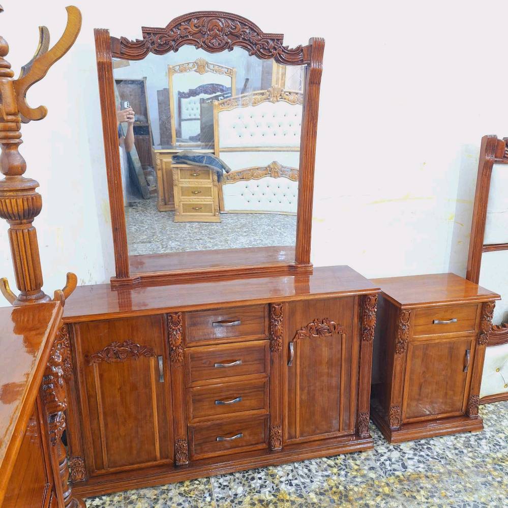 الغرفة المعروضة تتكون من سرير ملكي مع تفصيلات فخمة وزخارف خشبية أنيقة، بالإضافة إلى دولاب ضخم بأبواب متعددة ومرآة كبيرة تضيف لمسة كلاسيكية للغرفة. التصميم متكامل ويحتوي على كومودينات وأماكن تخزين متعددة. مثالية لمن يبحث عن ديكور راقي وعملي في نفس الوقت.