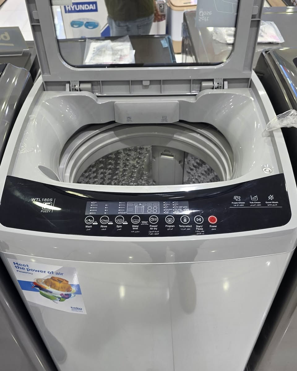 عرض خاص يمنا فقط وكمية محدودة حالياا 👌 بيكو (**Beko**).
 * **الموديل:** **WTL180S** (يظهر بوضوح بجانبه شعار تقنية **FUZZY** للتحكم الذكي).
 * **نوع الغسالة:** غسالة ملابس **فوق أوتوماتيك (تحميل علوي - Top Load)**.
 * **اللون:** رمادي فضي (Silver/Grey) عصري وأنيق يتناسب مع مختلف الديكورات الحديثة.
 * **الباب العلوي:** يتميز بوجود زجاج شفاف يتيح رؤية الملابس بالداخل أثناء الغسيل، ومزود بتقنية **Soft Close** (الإغلاق الهادئ والآمن لحماية الباب من الصدمات).
### 2. لوحة التحكم والبرامج (Control Panel)
اللوحة رقمية بالكامل تعمل باللمس وتأتي باللغتين العربية والإنجليزية لسهولة الاستخدام، وتتضمن الخيارات التالية:
 * **شاشة عرض رقمية (LED):** تظهر الوقت المتبقي وحالة البرنامج الحالي.
 * **أزرار التحكم الأساسية:** * الغسيل (**Wash**)، الشطف (**Rinse**)، العصر (**Spin**).
   * مستوى الماء (**Water level**).
   * ضبط مسبق / تجفيف بالهواء (**Preset / Air dry**) للحصول على تجفيف إضافي فعال.
   * اختيار البرنامج (**Program**) واختيار درجة الحرارة (**Temp select**).
   * أزرار التشغيل الرئيسية: البدء/المؤقت (**Start/Pause**) وزر الطاقة (**Power**).
 * **ميزات خاصة مدمجة:** * تنظيف الرغوة (**Foam Clean**).
   * تنظيف الحوض (**Tub Clean**) للحفاظ على نظافة الغسالة من الرواسب.
   * الغسيل الهادئ (**Quiet Wash**) لتقليل الضوضاء والاهتزاز.
### 3. التصميم الداخلي والحلة (الحوض)
 * **الحلة الداخلية:** مصنوعة من **الاستانلس ستيل (Stainless Steel)** المقاوم للصدأ عالي الجودة، وتأتي بتصميم بارز (شبه الماسي) لحماية الأقمشة الحساسة من التلف وزيادة كفاءة التنظيف.
 * **المروحة السفلية:** مروحة قوية مصممة لتوليد تيارات مائية متطورة لمنع تشابك الملابس وتوزيع المسحوق بشكل مثالي.
 * **مداخل المنظفات:** تحتوي على درج مخصص مقسم لإضافة المسحوق (**Detergent**) ومنعم الأقمشة (**Softener**).
### 4. كفاءة الطاقة والملصقات الإرشادية
 * **ملصق كفاءة الطاقة:** يظهر على الغسالة ملصق تقييم استهلاك الطاقة (بالمستويات الملونة)، مما يشير إلى توافقها مع معايير توفير استهلاك الكهرباء والماء.
 * **شعار "Meet the power of air":** ملصق أمامي يبرز تقنية الاعتماد على تدفق الهواء (**PowerDry**) للمساعدة في تجفيف الملابس بشكل أسرع وأكثر كفاءة.
👇✅️للحجز والاستفسار يرجى مراسلة الصفحة الرئيسية او اتصال و اتساب على أرقام التالية 
***********
***********
 https://www.facebook.com/share/1CMd7FzpkH/
العنوان /💎✅️ معرض الجوهرة ✅️💎
موصل / حي القادسية الثانية مقابل بدالة الزهور مجاور مول الكوثر 
***********
***********
