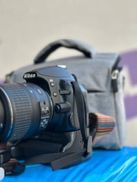 نيكون D3100 • عدسة 18-55 • شاحن وحزام وبطاريتين