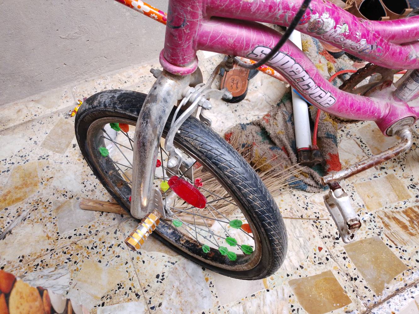 عندي دراجة هوائية لونها وردي، مناسبة للأطفال. الدراجة بحالة متوسطة ومزودة بزينات على العجلات لتضيف مظهر مرح للأطفال. عجلاتها بحاجة لتنظيف بسيط، وبعض الأجزاء قد تكون بحاجة إلى صيانة خفيفة.
