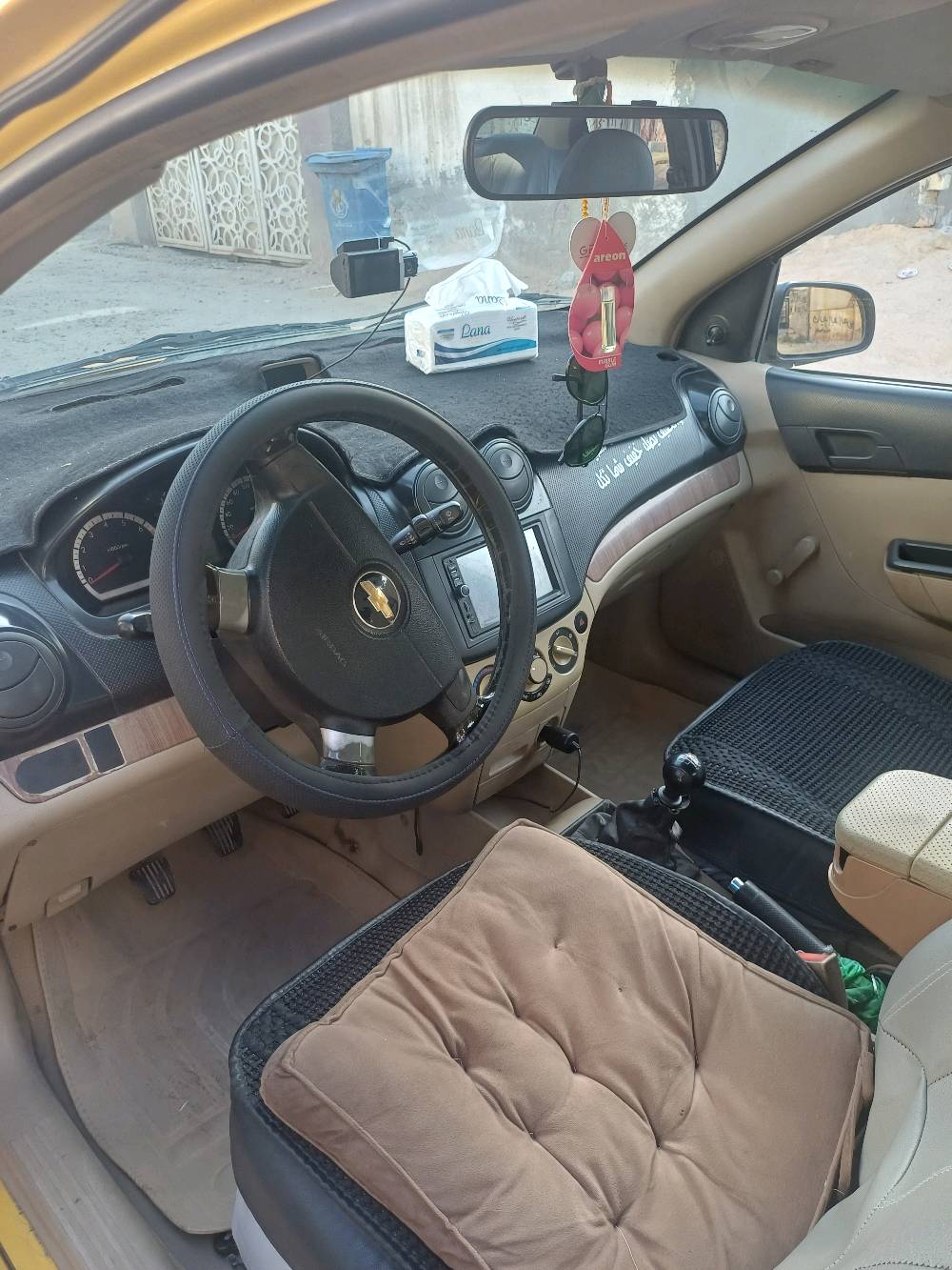 سيارة شيفروليه صفراء، مناسبة للعمل كسيارة أجرة. حالتها الخارجية جيدة مع بعض الخدوش البسيطة. السيارة نظيفة من الداخل ومُجهزة بمقاعد مريحة. المكان بغداد، واللوحات تشير إلى أنها مُرخصة كسيارة أجرة.