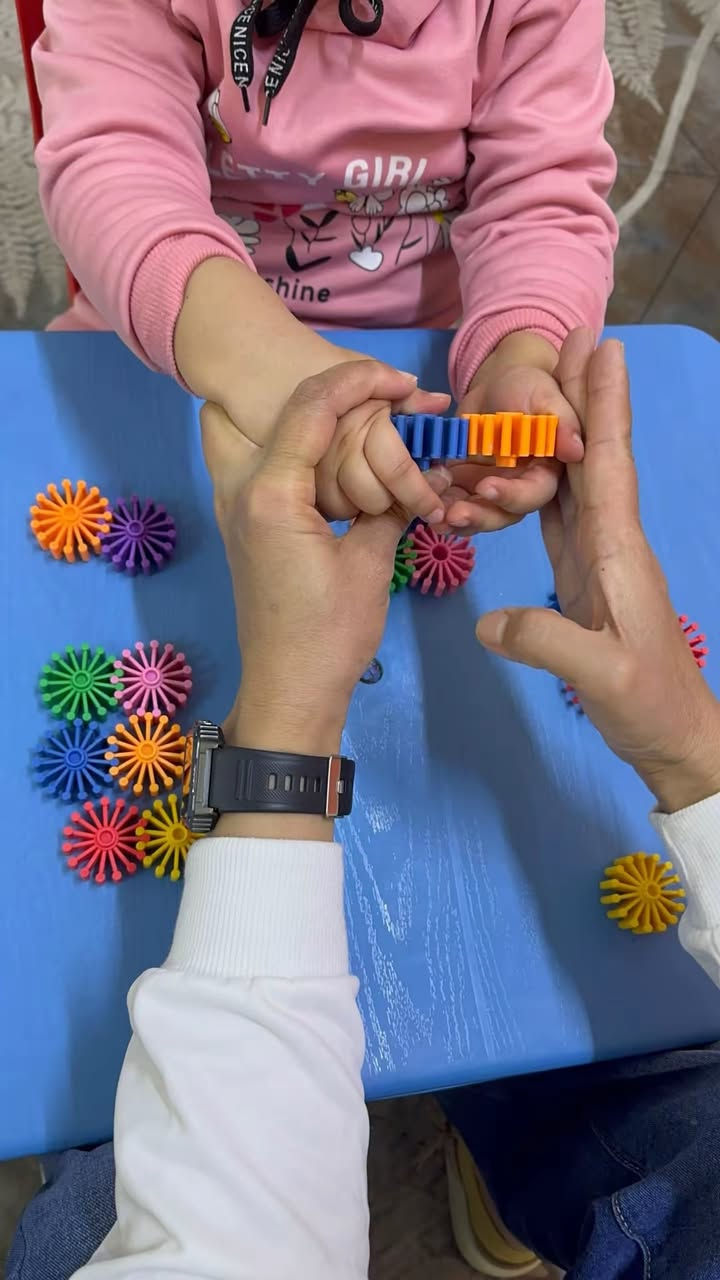 🧠قبل ان يتكلم يجب ان يفهم!بناء"اللغة الاستقبالية " لطفل التوحد#
كثير من الأهالي يسألون"متى سيتكلم طفلي؟" ولكن السؤال الأهم هو :هل يفهم طفلي ما أقوله؟"🧐
اللغة الاستقبالية هي " المخزن"  الذي يبنيه الطفل ؛ فإذا امتلأ. هذا المخزن بالفهم،فاض بالكلمات لاحقا. في جلساتنا، نركز على تحويل الكلمات المجردة إلى مفاهيم ملموسة.
🛠️كيف نطور اللغة الاستقبالية ( كما تظهر في الصورة)؟
1.الربط بين الكلمة والمجسم(Matchjng):
نستخدم البطاقات الملونة ( ازرق- اصفر- احمر)
لتعليم الطفل تمييز الألوان. عندما أقول " أعطني الأزرق" ويختاره الطفل فهذا يعني ان الدماغ بدأ يربط الرمز الصوتي بالصورة البصرية
2. تنفيذ الأوامر البسيطة(Following Commands):
من خلال الأنشطة الحركية مثل " امسك القلم " او " ضع المكعب" تدرب الطفل على فك تشفير الجمل وتحويلها إلى فعل ملموس
3.المساعدة الجسدية ثم التلاشي: 
في البداية قد تساعد الطفل " يدا بيد"( كما في الصور) ليعرف المسار الصحيح ثم نسحب يدانا تدريجياً حتى يستجيب للطلب اللفظي وحده 
4. تقليل المشتتات: 
لاحظوا بيئة العمل ، هادئة ومنظمة لتساعد الطفل على التركيز فقط على المثير السمعي والبصري الذي نقدمه له . 
تذكروا دائما
اللغة الاستقبالية  هي الجسر الذي يربط عالمنا بعالمهم، كلما كان الجسر قوياً كان التواصل اسهل وأسرع✨✨

كل الحب لإيطاليا الصغار ولعائلاتهم الصابرة❤️🙌
طيف التوحد#اللغة الاستقبالية # تأهيل# تخاطب# توعية # تدخل مبكر# نطق وتواصل

معهد تنمية الطفولة 
(جلسات فردية):
العنوان البنوك/ شارع التربية 
هناك جلسات مجانية للطفل اول يومين 
الدوام من الاحد للخميس 
يوجد خطوط نقل:
للحجز والتسجيل 📞***********
