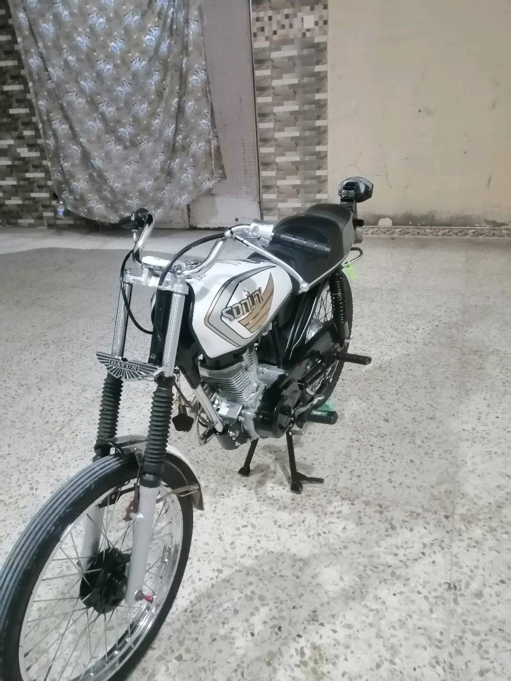 دراجة نارية من نوع دايون، تصميم كلاسيكي وأنيق باللون الأبيض. الدراجة في حالة جيدة ومناسبة للاستخدام داخل المدينة أو المسافات القصيرة. مناسبة لعشاق الدراجات الكلاسيكية وتوفر قيادة مريحة.