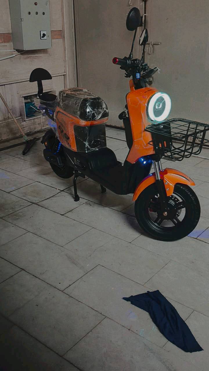 دراجة كهربائية جديدة وغير مستعملة، لون برتقالي مميز وضوء أمامي قوي. مثالية للتنقل السريع في المدينة أو الأحياء السكنية. تأتي بسلة أمامية لحمل الأغراض الشخصية ومقاعد مريحة. فرصة ممتازة لشراء وسيلة نقل صديقة للبيئة وموفرة للطاقة.