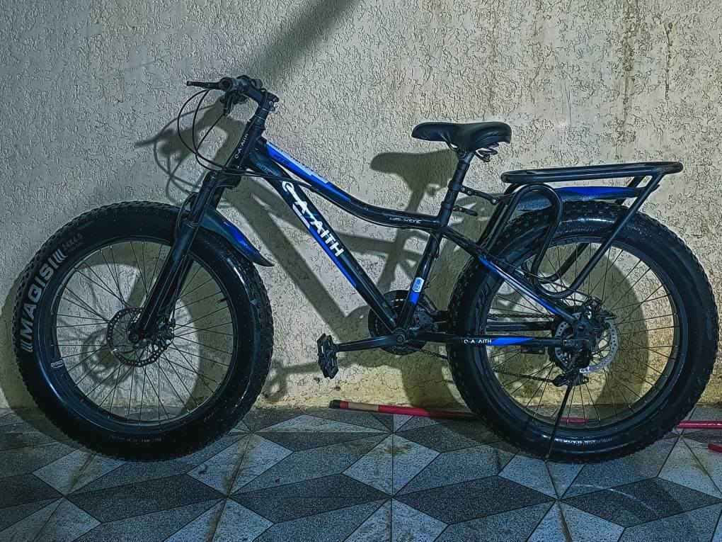 البايسكل من نوع Fat Bikeاذا ما تعرف سعرة وما تعرف مميزاتة اطلع كبل لان حاجة نضيفة وجديدة   . الإطارات والعجلات
​النوع: إطارات عريضة جداً (Fat Tires) من ماركة MAGISI.
​المقاس: يظهر على الإطار مقاس 24x4.0. هذا يعني أن قطر العجلة 24 إنش وعرض الإطار 4 إنش، وهو ما يوفر ثباتاً عالياً وامتصاصاً ممتازاً للصدمات.
​2. الهيكل (Frame)
​الماركة: C-AAITH (موديل HAWKEYE).
​التصميم: هيكل جبلي (Mountain Bike) بإنحناءة في الأنبوب العلوي لتسهيل الركوب والنزول.
​اللون: أسود مع لمسات باللون الأزرق والأبيض.
​3. نظام السرعات والفرامل
​ناقل السرعات: يحتوي على نظام سرعات متعددة (تروس أمامية وخلفية)، مما يساعدك في الصعود أو السرعة على الطرق المستوية.
​الفرامل: يعتمد على فرامل ديسك (Disk Brakes) أمامية وخلفية، وهي توفر قوة كبح أفضل بكثير من الفرامل التقليدية، خصوصاً في الأجواء الماطرة أو الموحلة.
​4. الإضافات والميزات الأخرى
​المساعدات (Suspension): يحتوي على مساعدات أمامية (Front Fork) لامتصاص الصدمات في الطرق الوعرة.
​الحمالة الخلفية: مزود بحمالة متينة خلف المقعد لنقل الأمتعة أو الأغراض.
​المقعد: مقعد عريض ومريح مزود بـ "سبرنغات" إضافية لزيادة الراحة أثناء القيادة الطويلة ب150 ديوانية, القادسية


**إذا كنت صاحب هذا الإعلان وتريد حذفه لأي سبب، رجاءا أرسل رسالة إلى الدعم الفني**